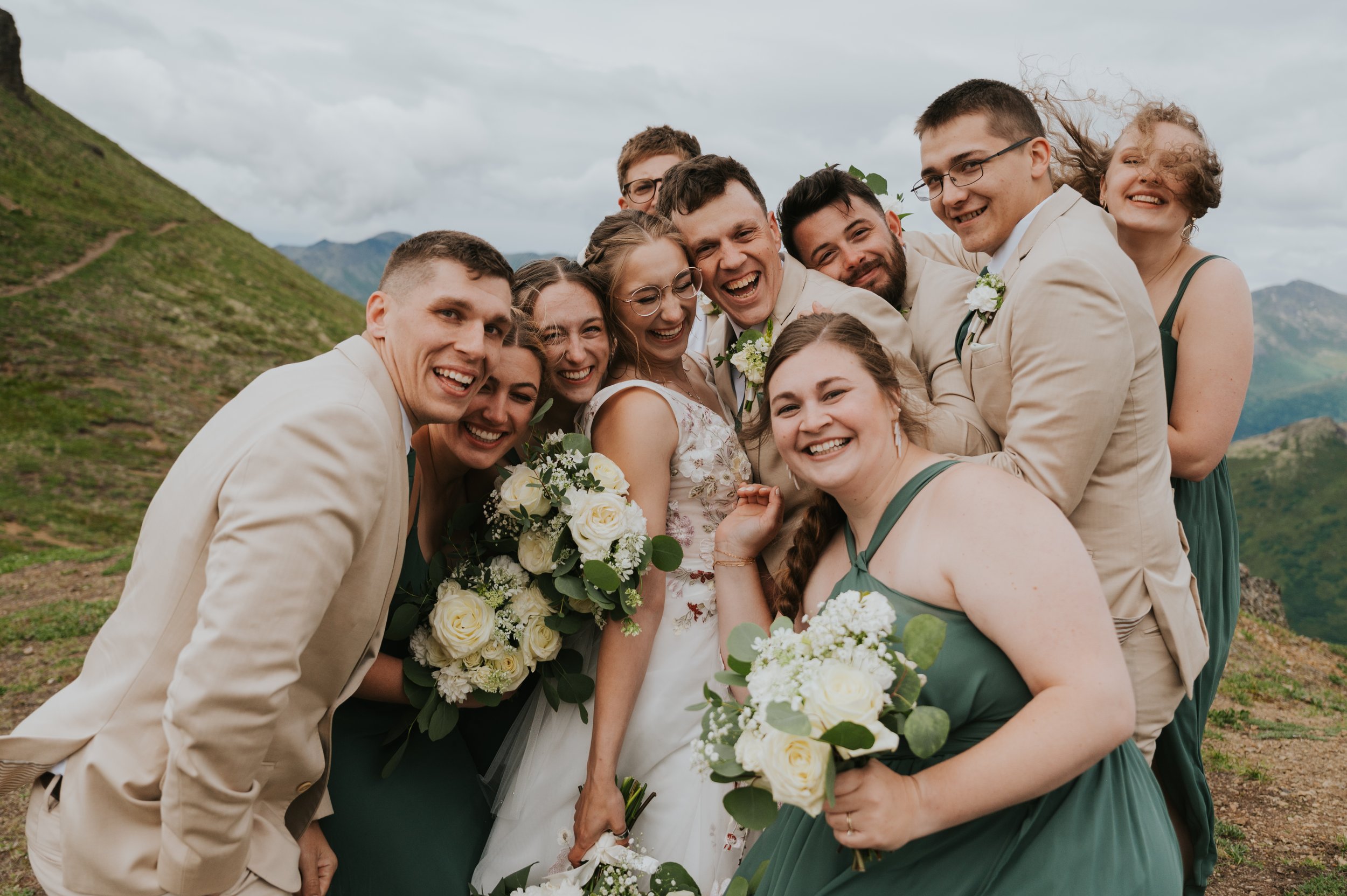 wedding party smiling on mountainside