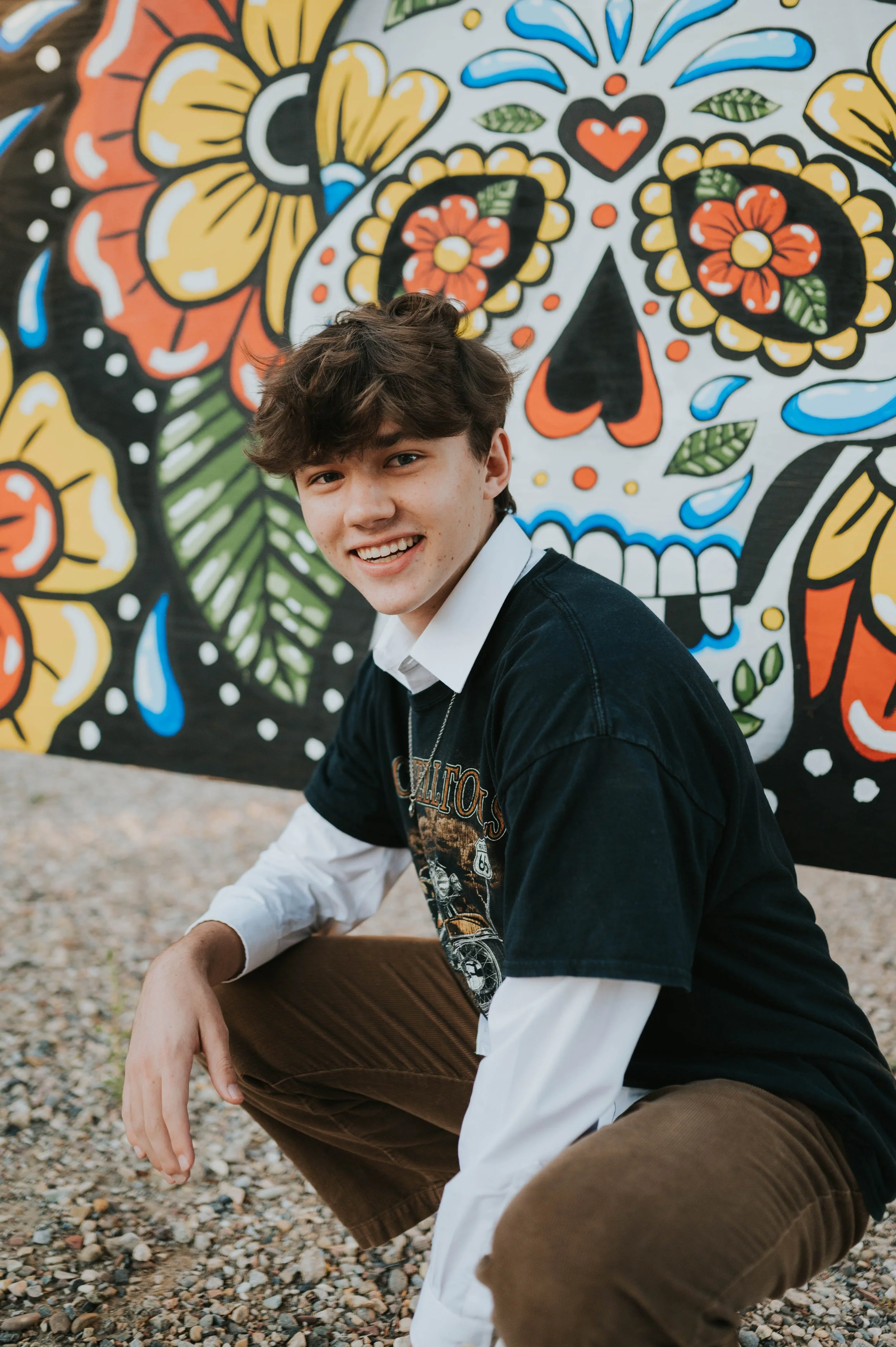 boy in front of mural smiling