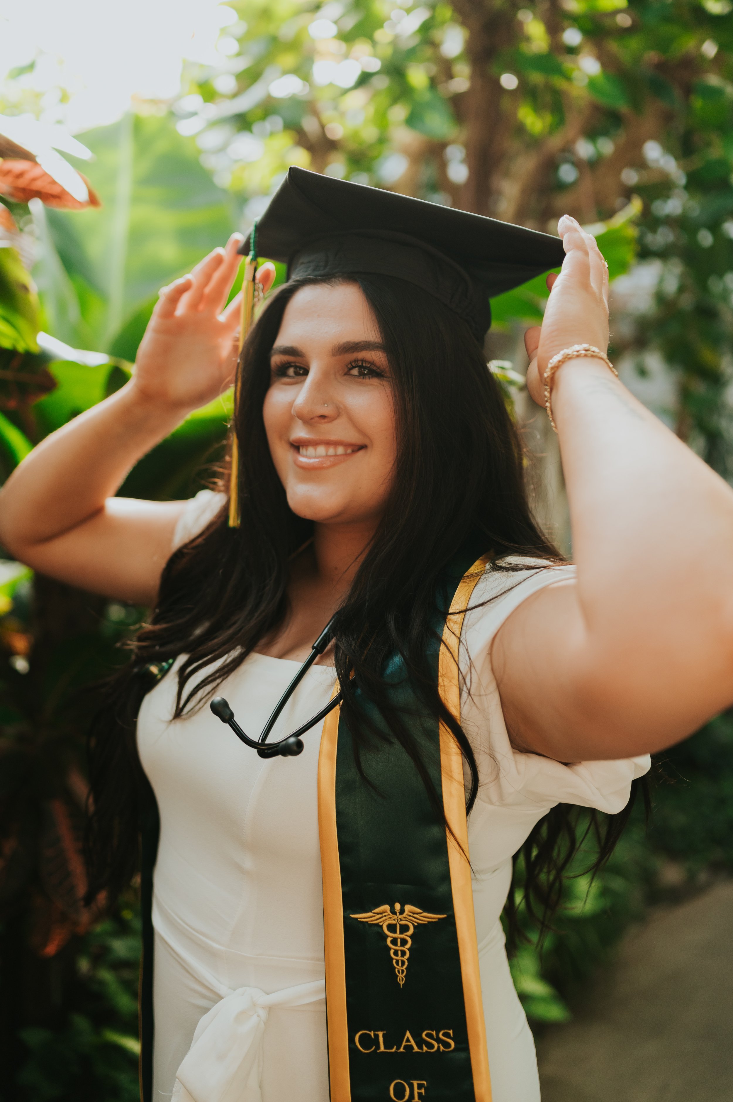 girl in graduation regalia holding cap