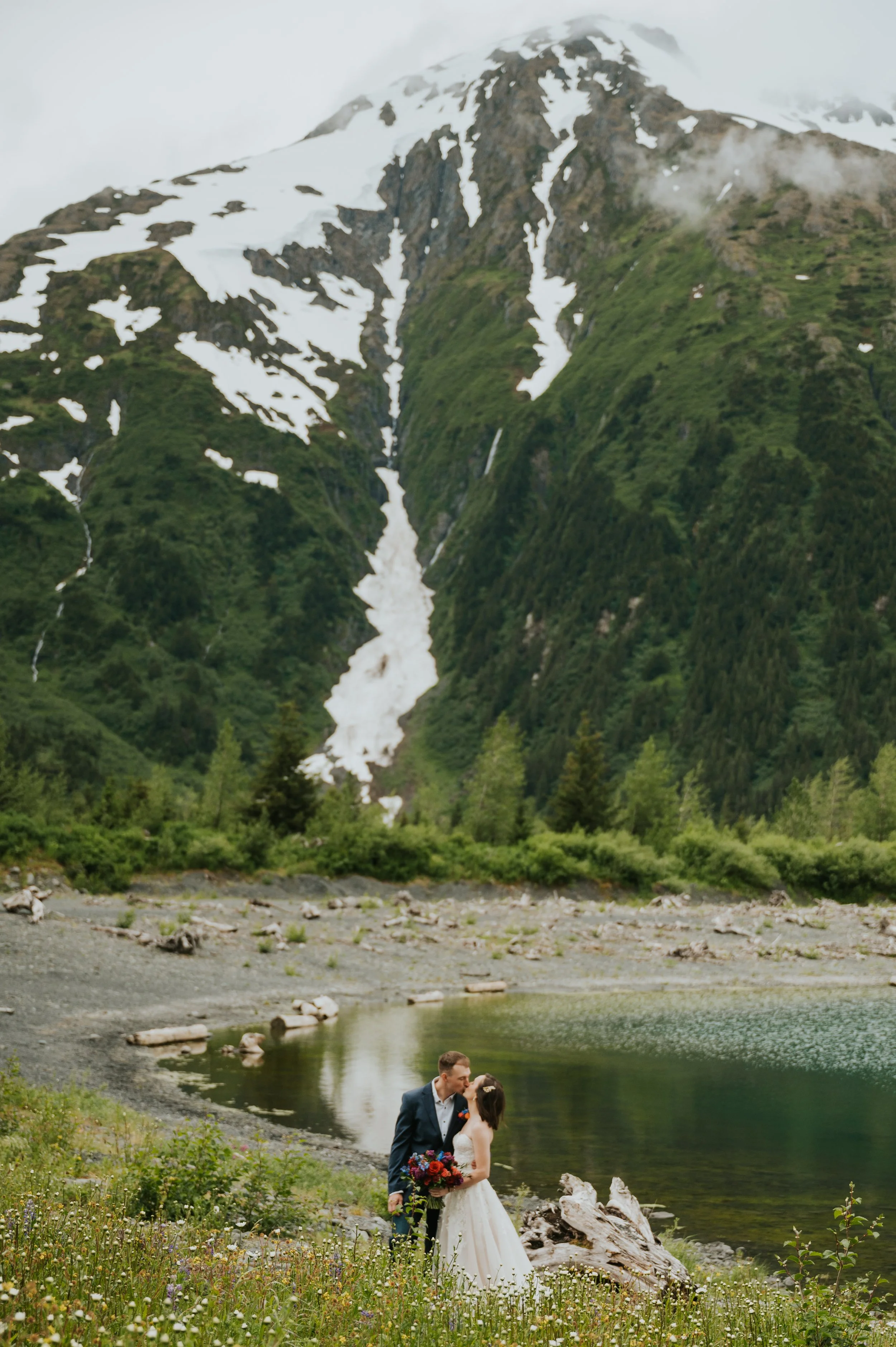 couple eloping by water under mountain
