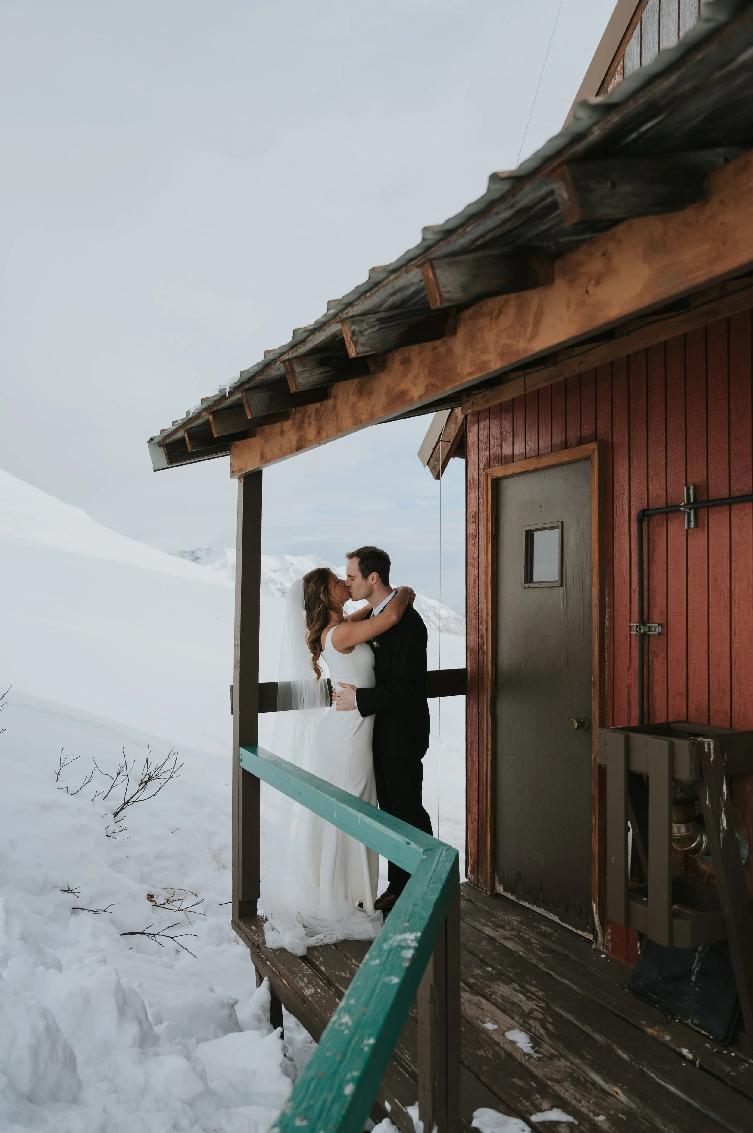 bride and groom in winter setting kissing on deck