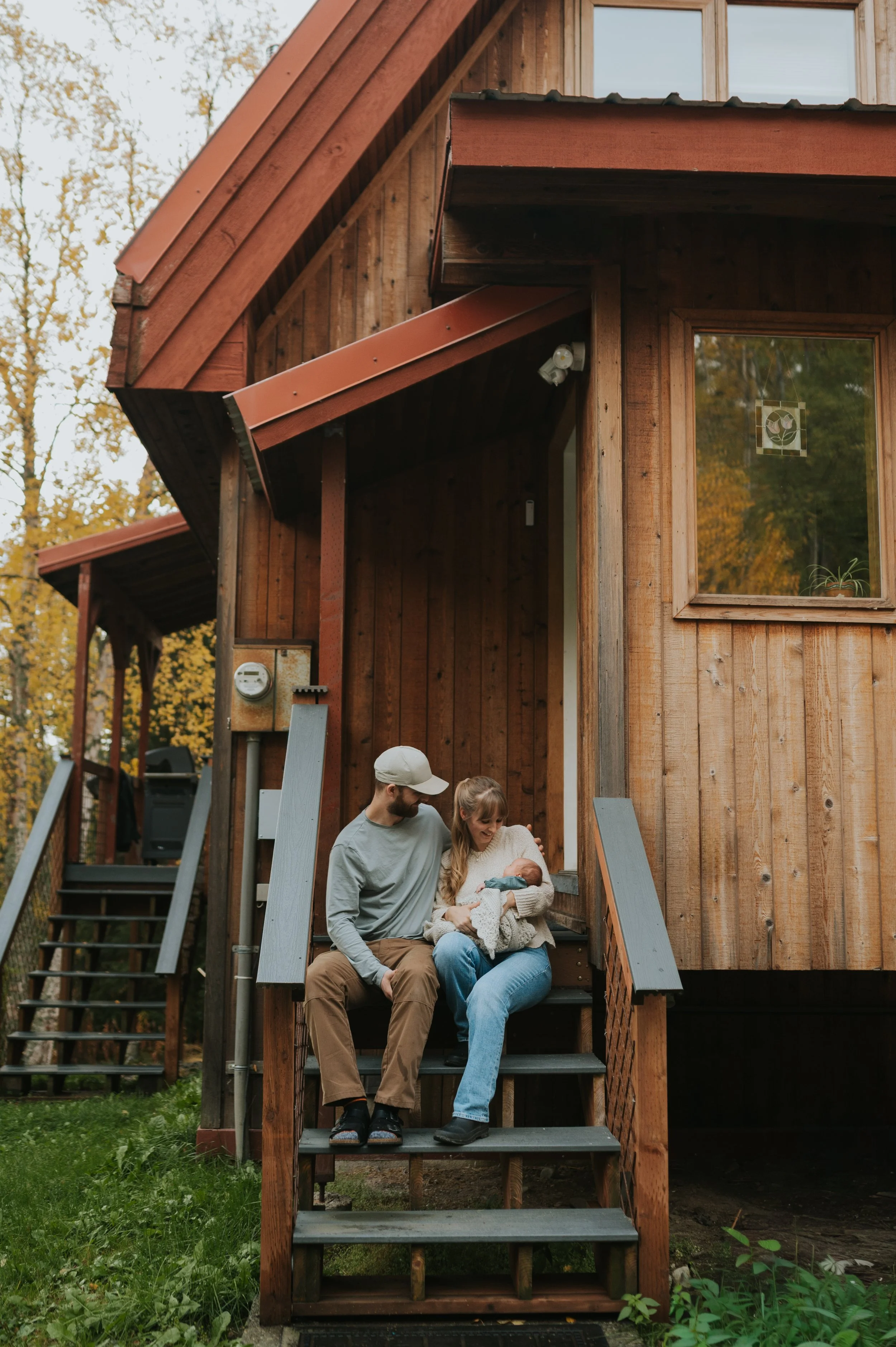 young couple on porch with infant