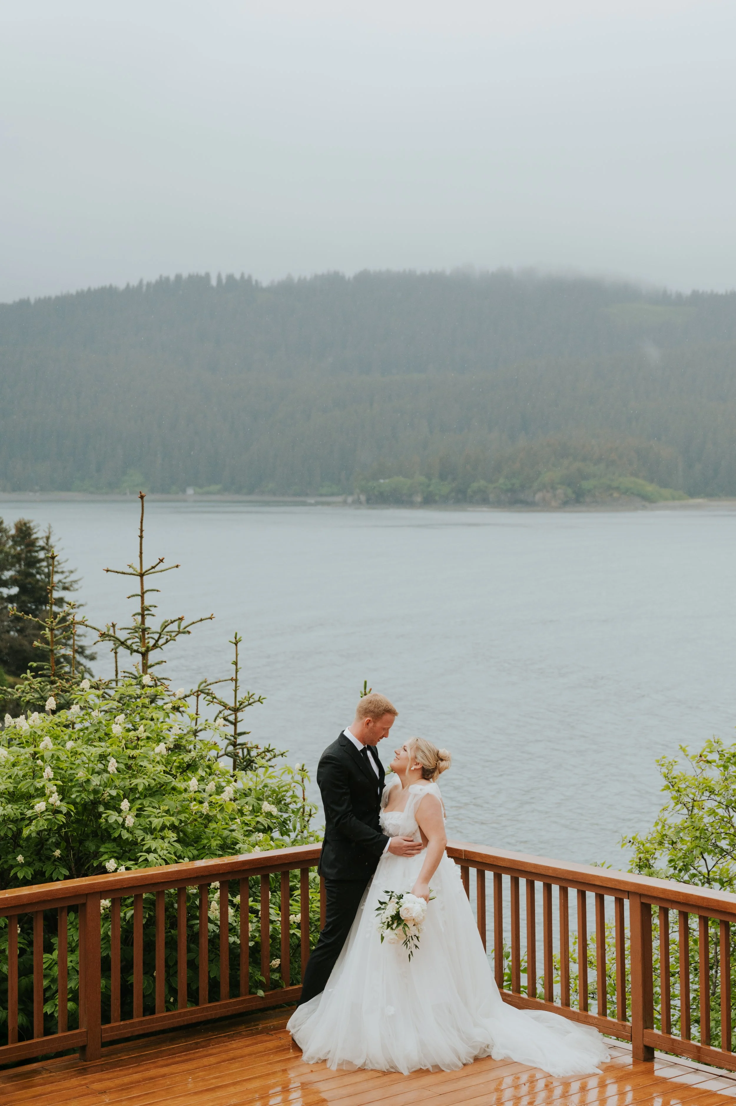 bride and groom smiling at each other on deck over ocean