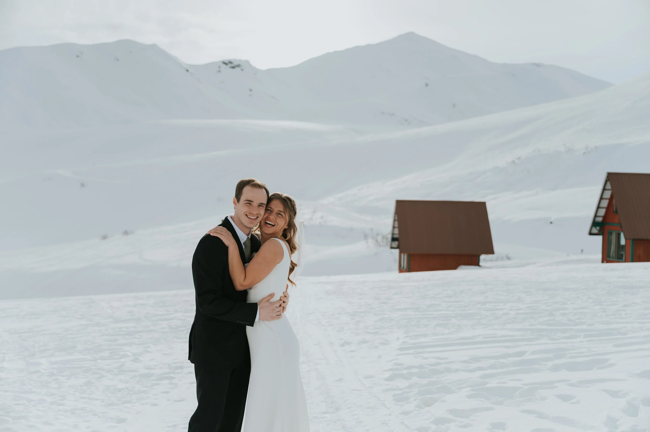 bride and groom in winter setting smiling at camera
