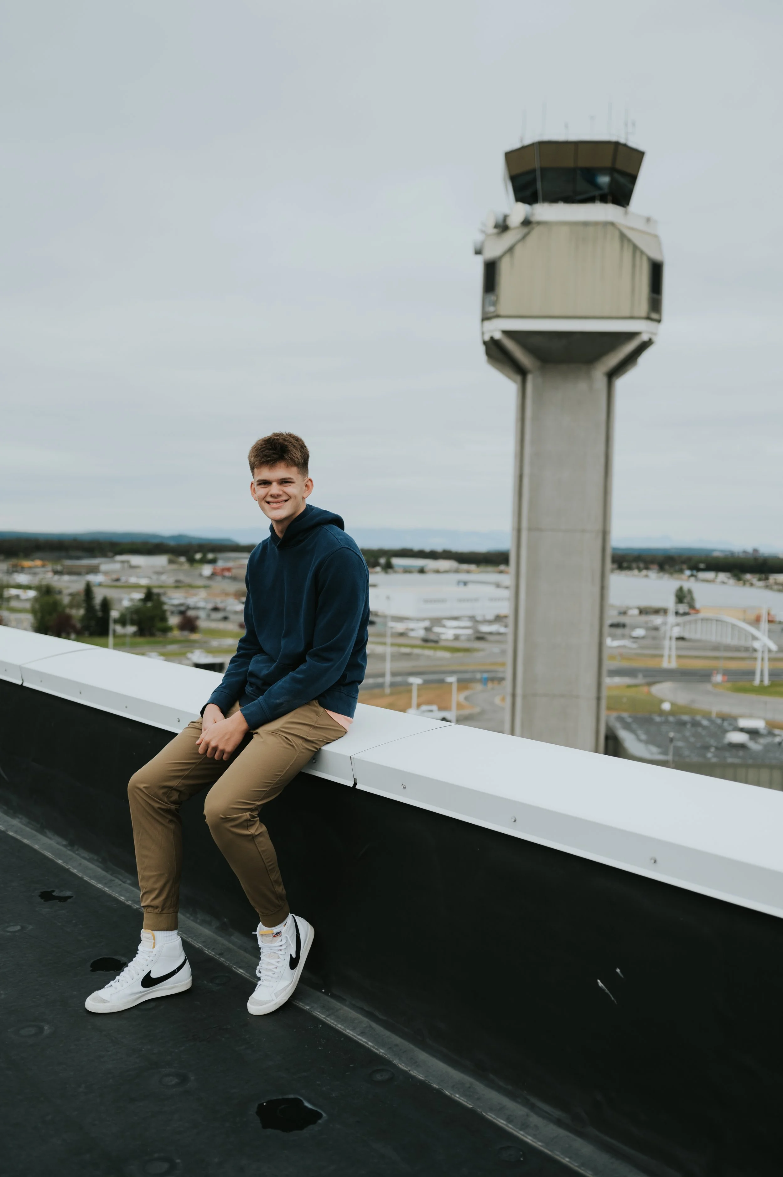 young man smiling in front of air traffic control tower