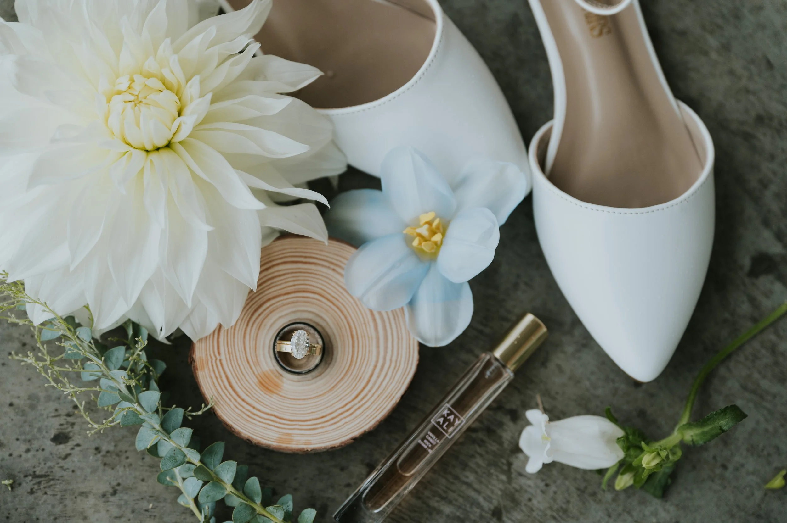 image of wedding day details, rings, shoes, perfume and flowers