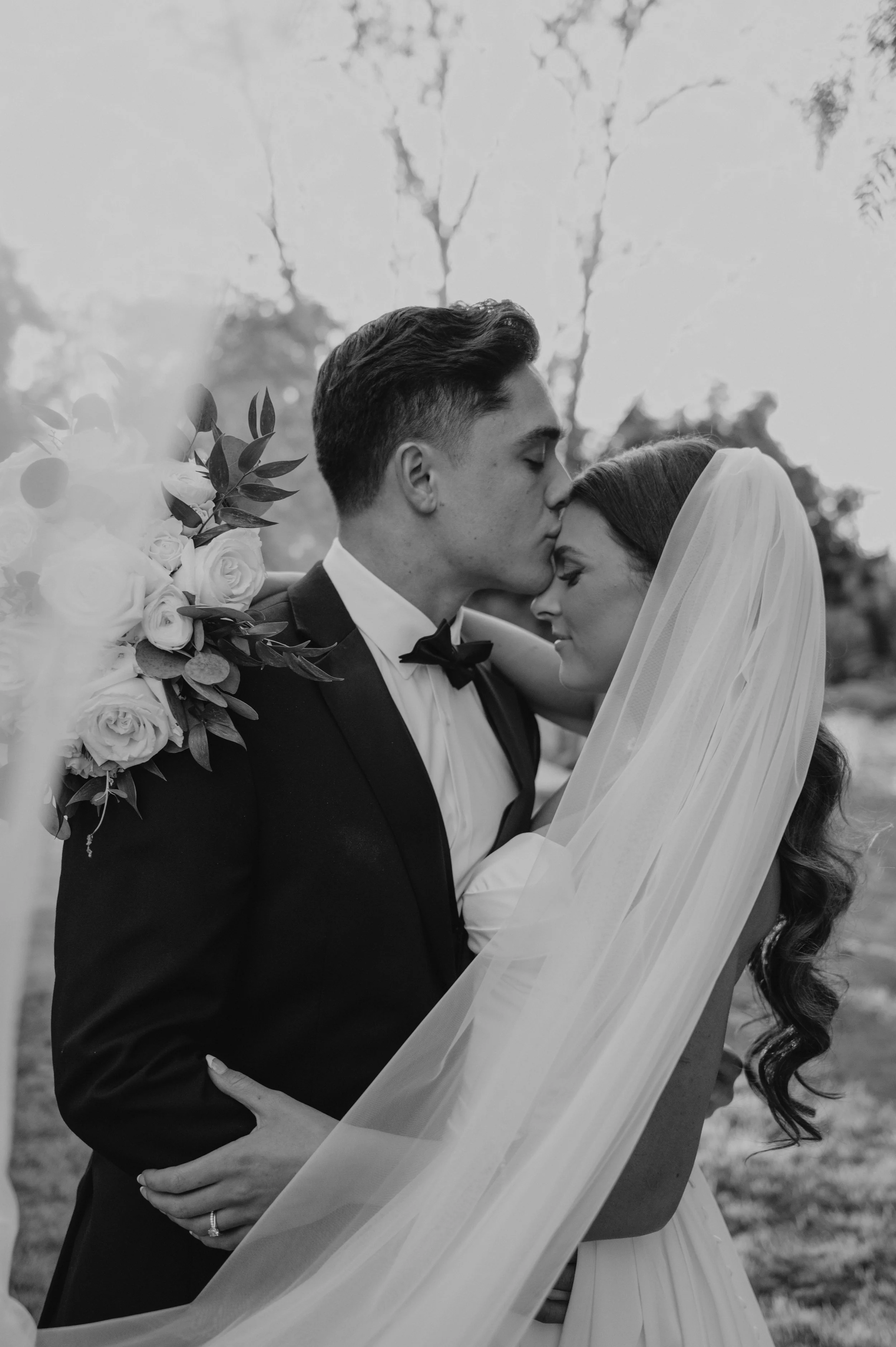 groom kissing brides head