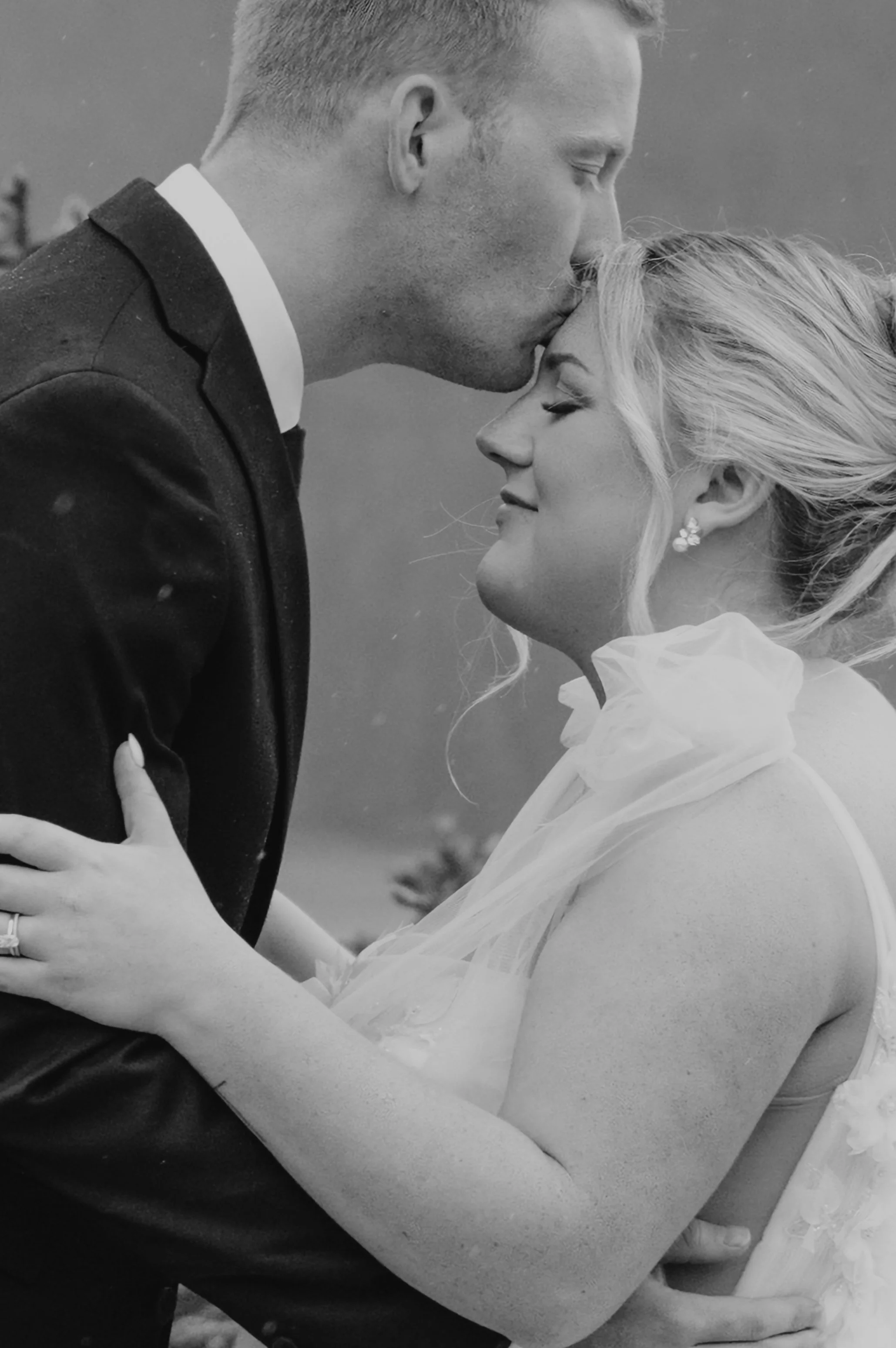 groom kissing brides forhead 