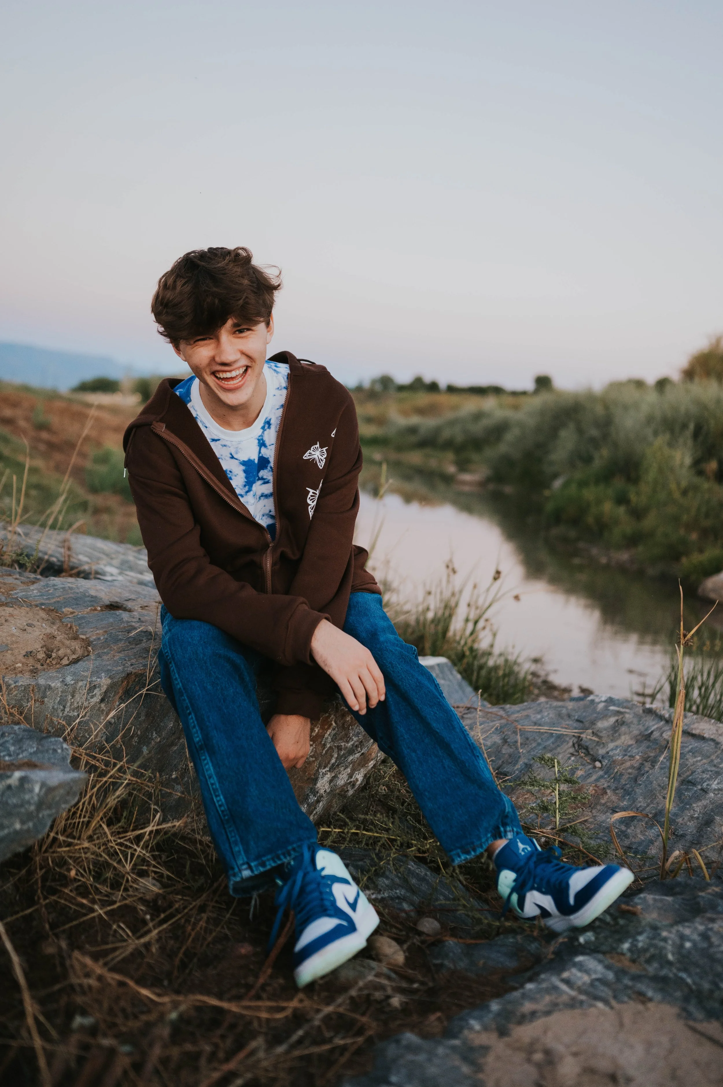 boy in front of water smiling