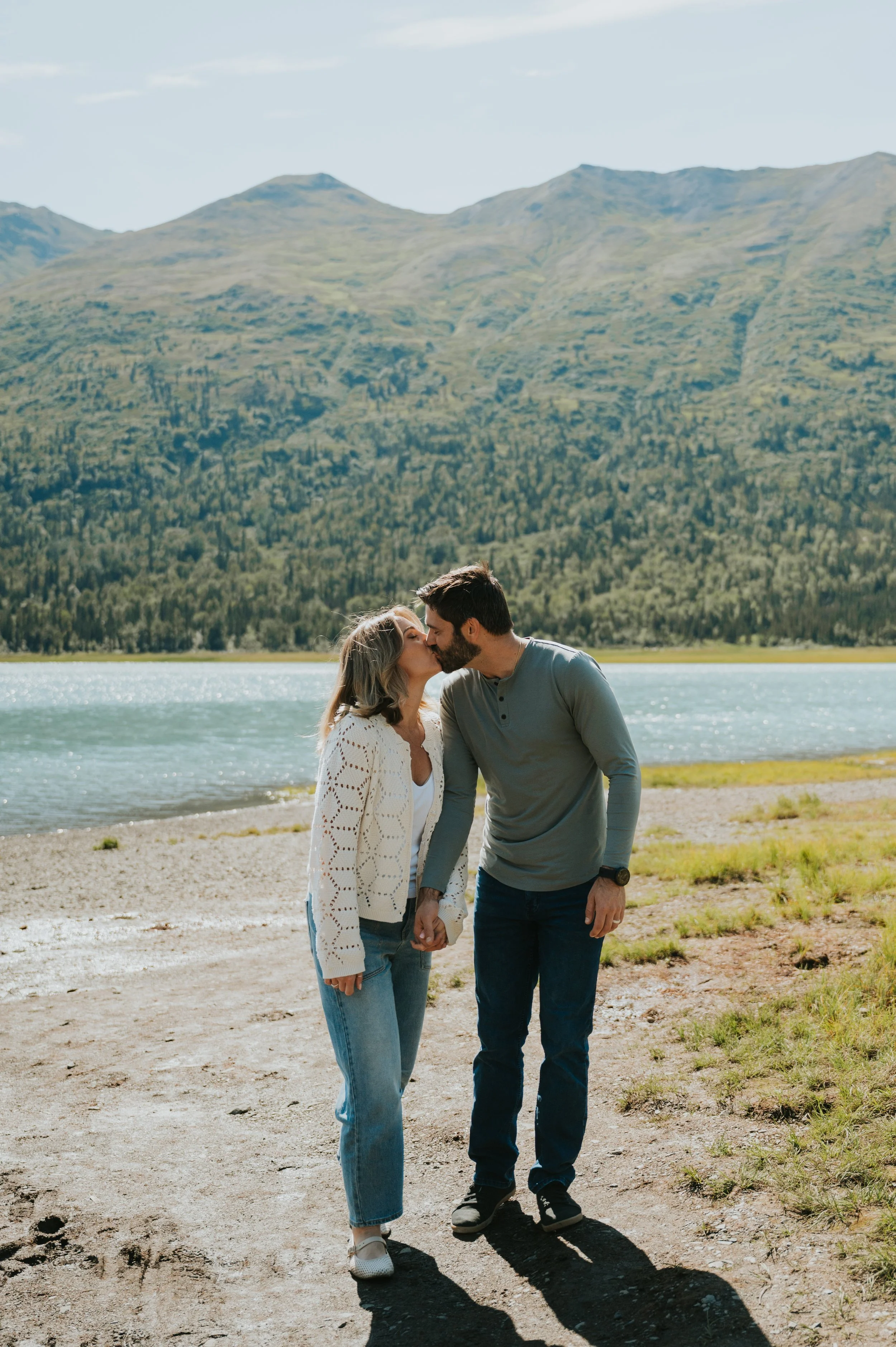 parents kissing at alpine lake