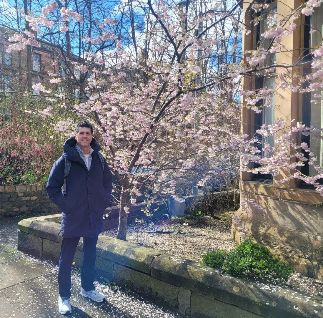 Frank Frulio of Glasgow stands next to a blooming cherry blossom.