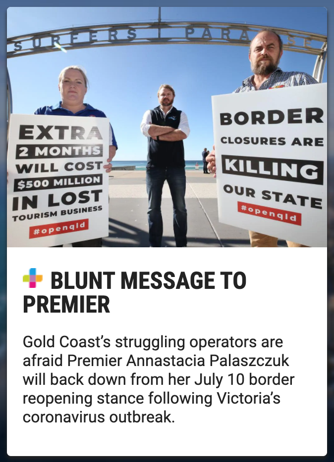 Three protesters standing by the beach holding signs about border closures and their economic impact, with a sign overhead reading 'Surfers Paradise.'