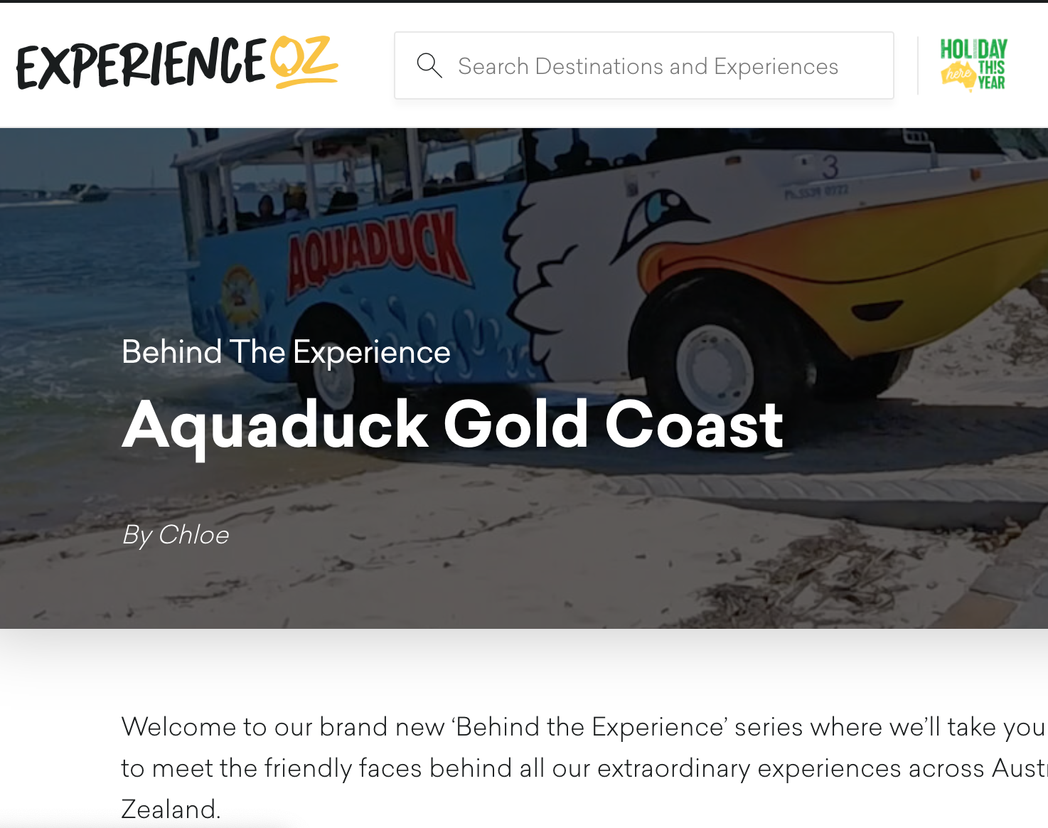 A boat with cartoon duck face and the name Aquaduck on the side, on a beach.