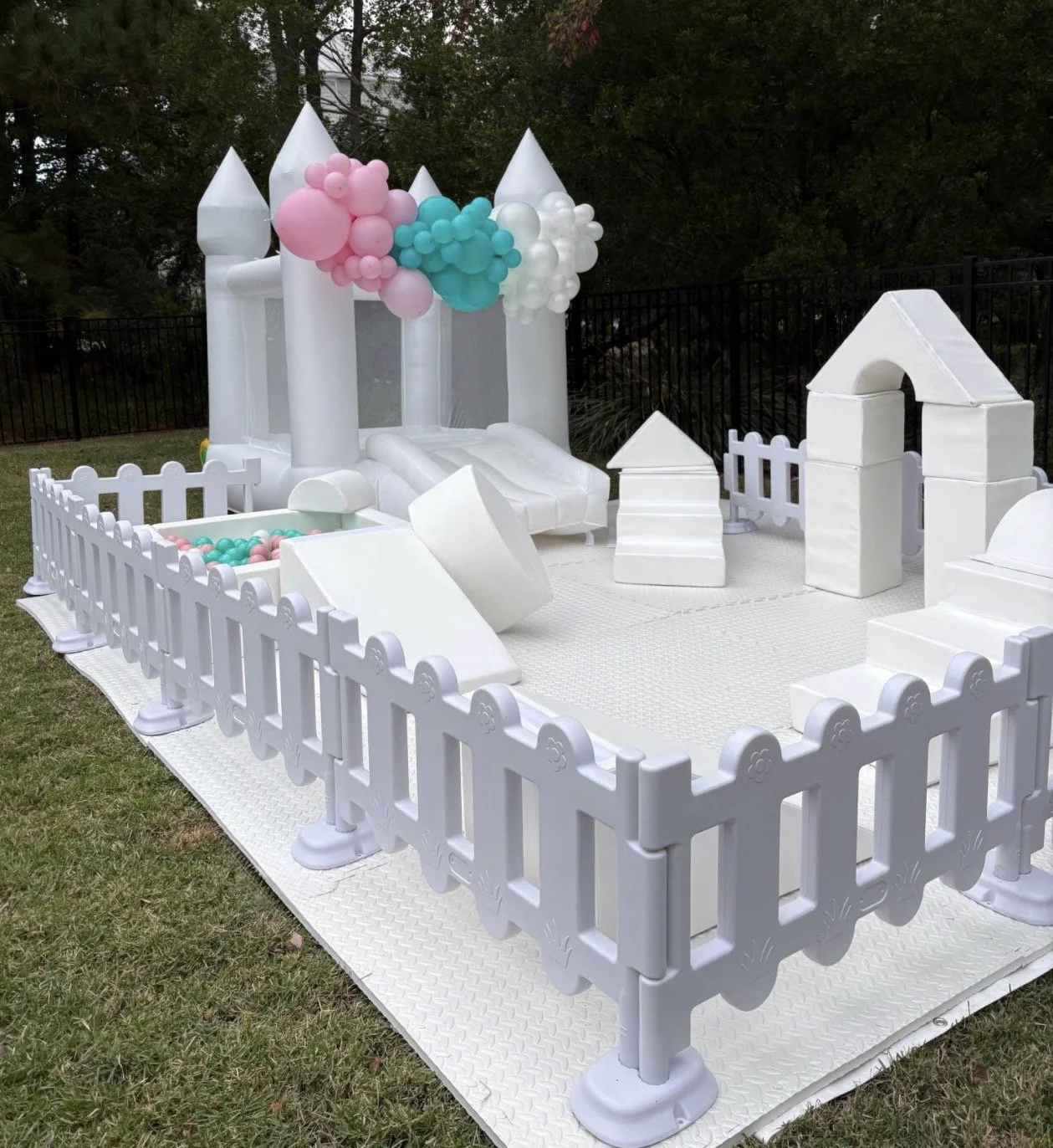 White Soft Play Rental in Charleston, SC. White Bounce House with Pink Teal and White Balloon Garland Custom Color Ball Pit Balls to Match 1st Birthday Theme