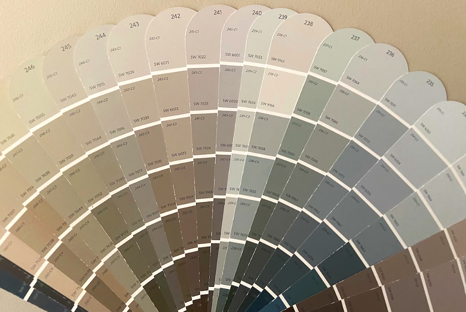 Sherwin Williams color swatch fan with various shades of beige, gray, and blue arranged in a semicircular display.