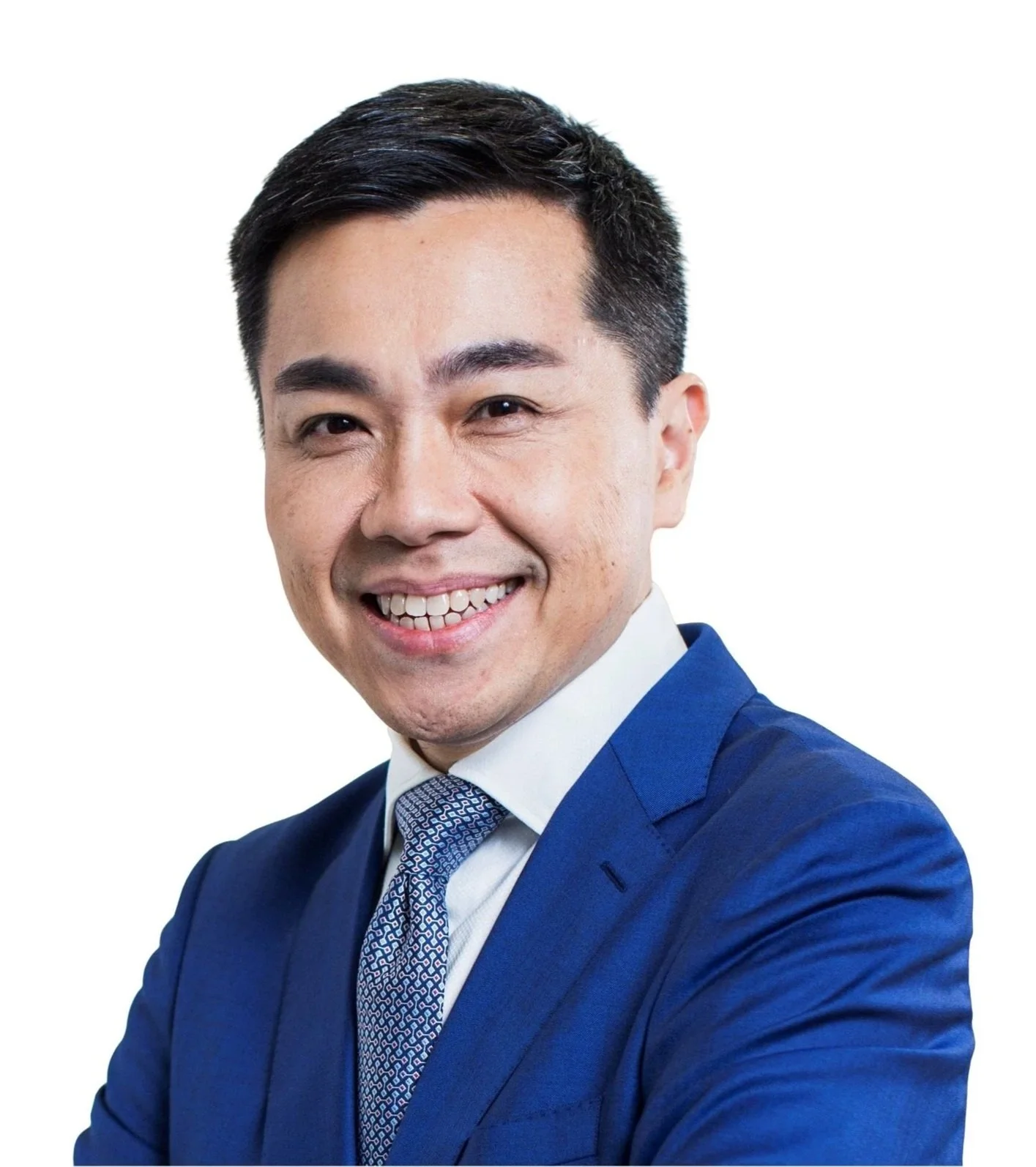 A smiling man in a blue suit and patterned tie posing against a plain white background.