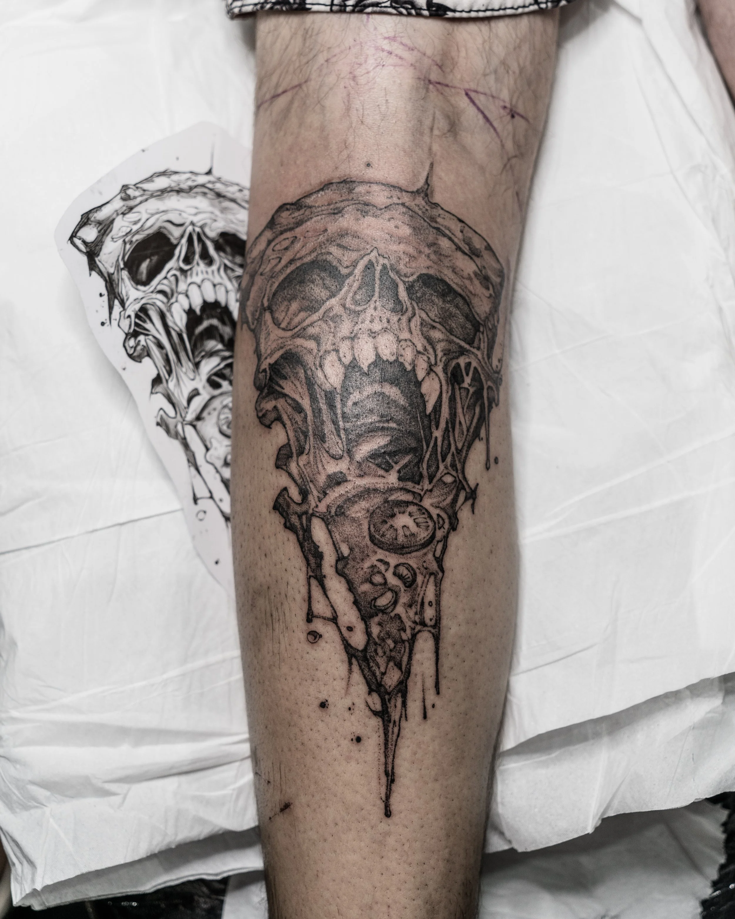 Black and grey tattoo of a skull pizza on lower leg by Jay C Tattoo, Brighton tattoo artist, UK
