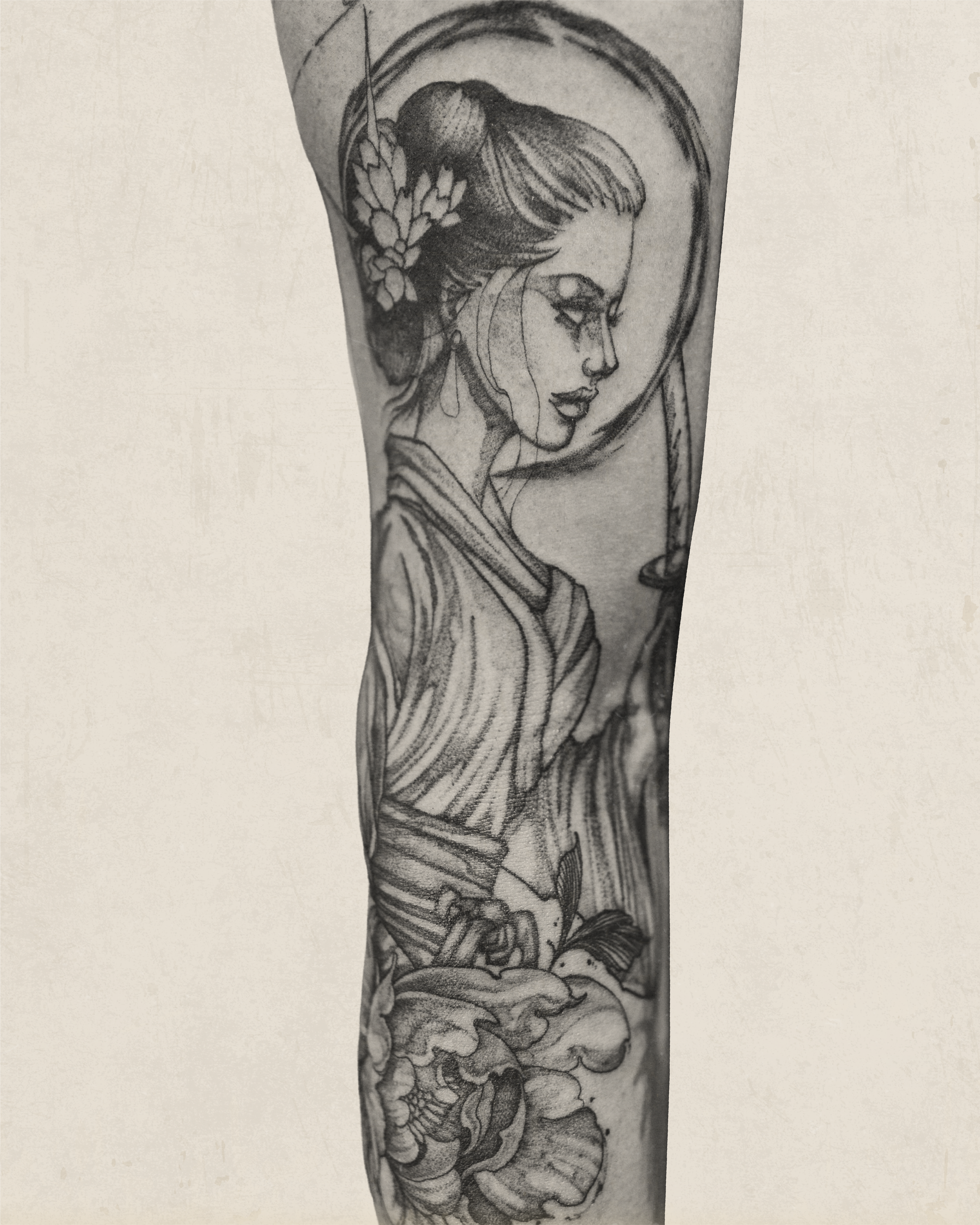 Black and grey tattoo of a woman with traditional Asian hairstyle, flowers and halo by Jay C Tattoo, Brighton and Hove tattoo artist, UK