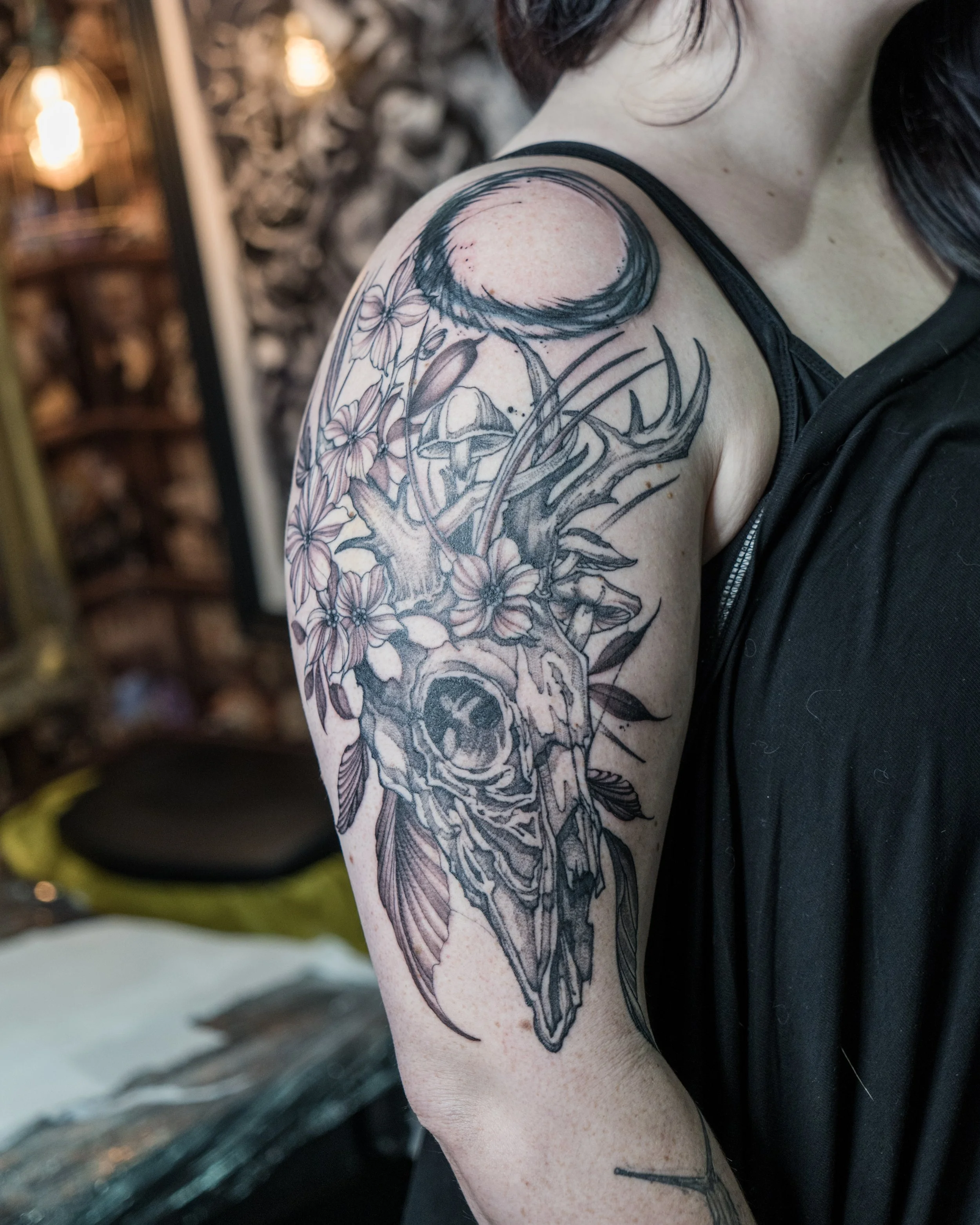 Black and grey tattoo of a deer skull with antlers, flowers and mushrooms by Jay C Tattoo, Brighton and Hove tattoo artist, UK
