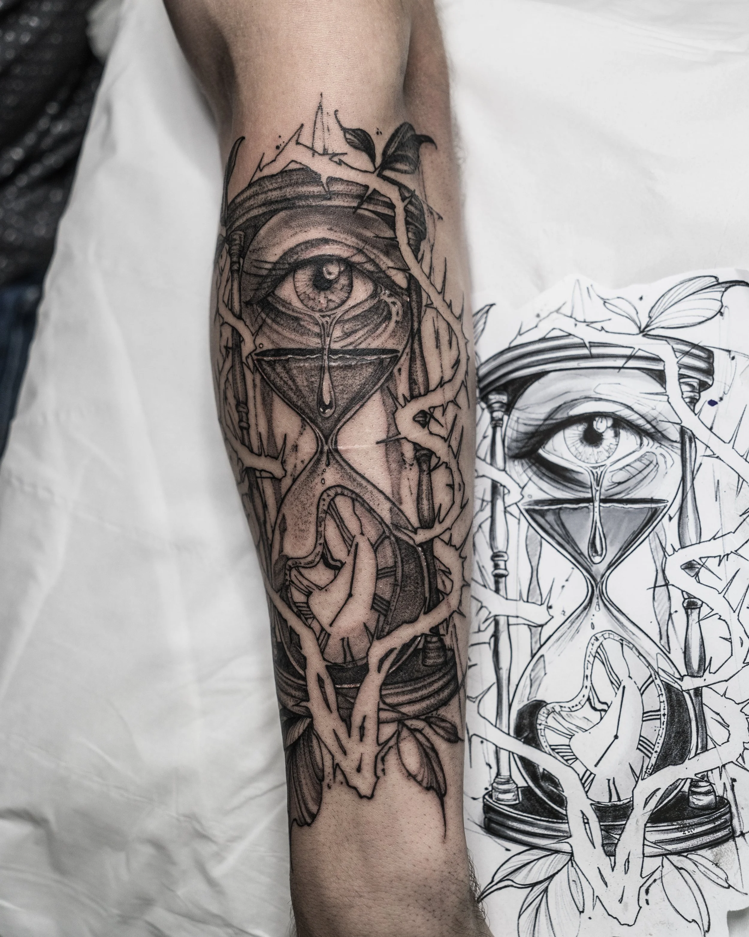 Black and grey tattoo of an eye with hourglass and vines on arm by Jay C Tattoo, Brighton and Hove tattoo artist, UK
