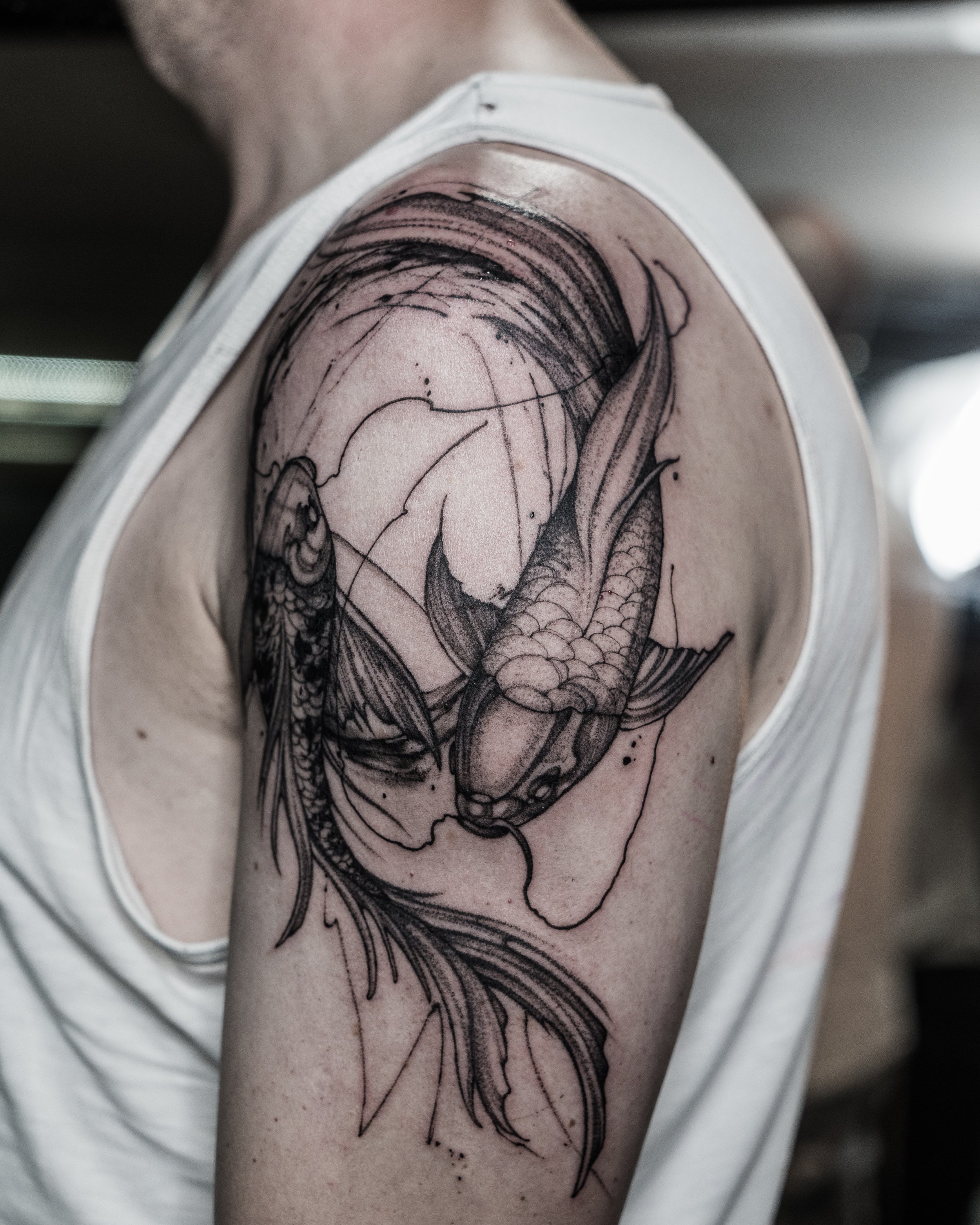 Black and grey koi fish tattoo on upper arm and shoulder by Jay C Tattoo, Brighton and Hove tattoo artist, UK
