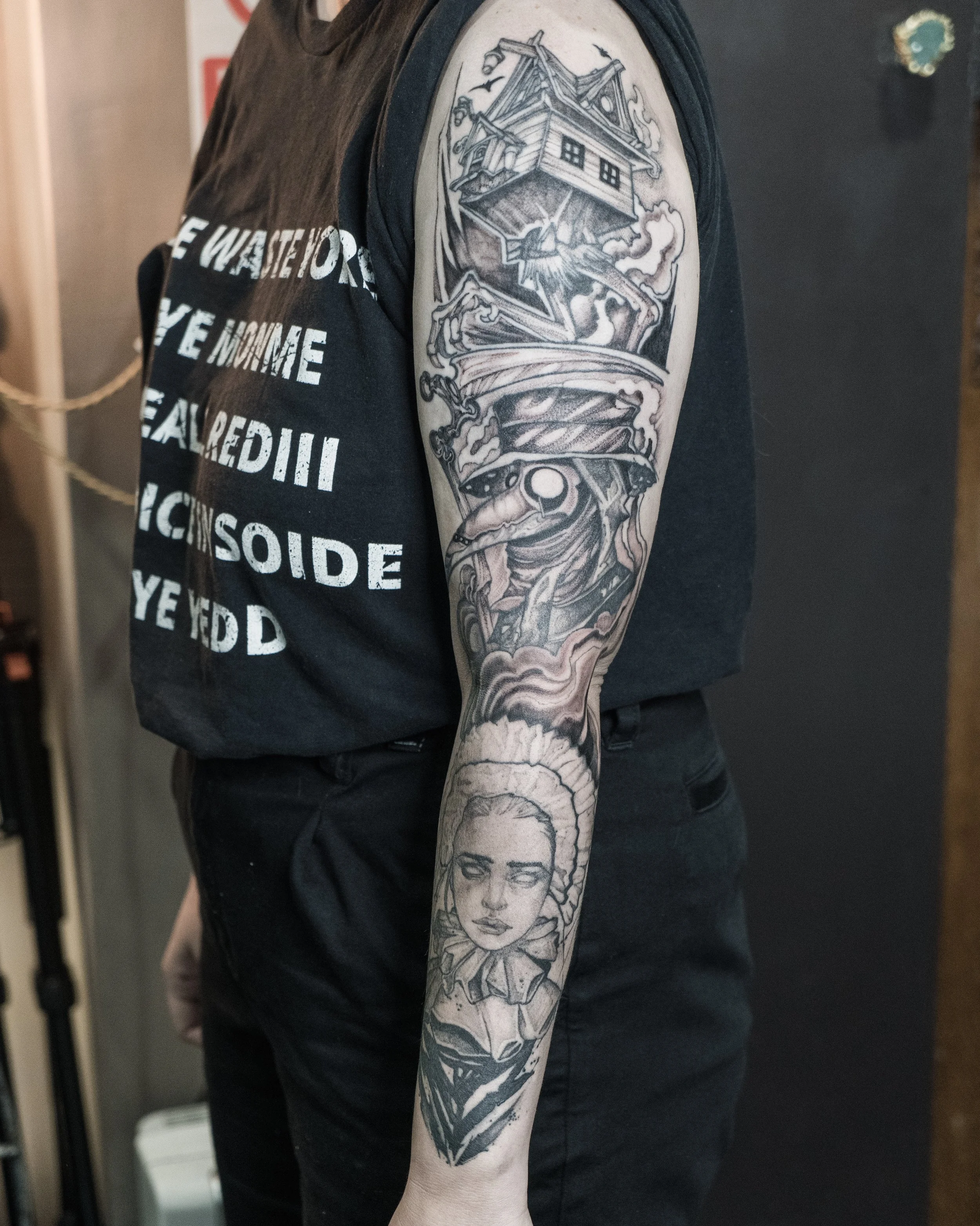 Black and grey tattoo sleeve featuring babayaga house, plague doctor, woman’s face and abstract elements by Jay C Tattoo, Brighton and Hove tattoo artist, UK

