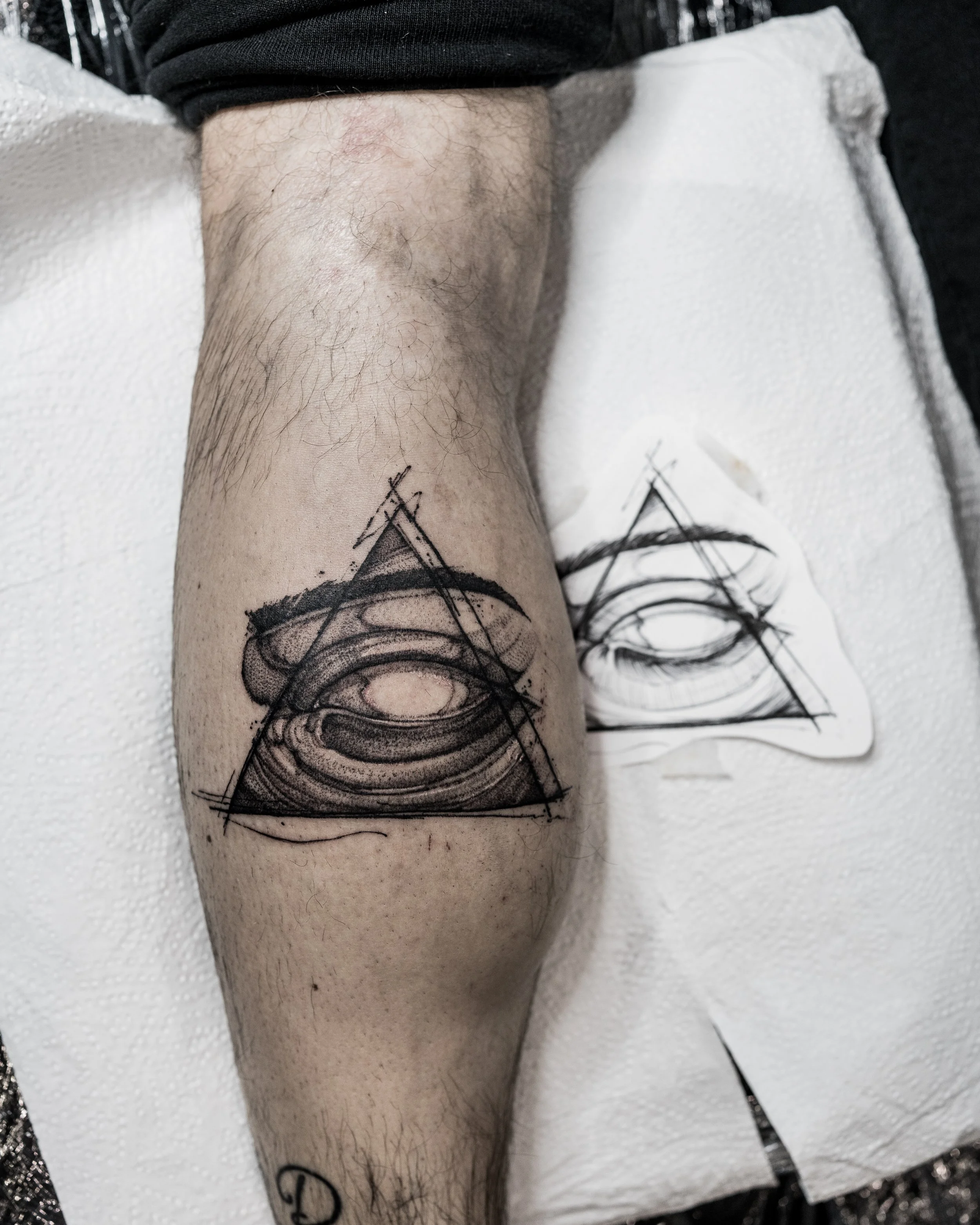Geometric eye tattoo inside a triangle on knee with sketch and tools by Jay C Tattoo, Brighton tattoo artist, UK