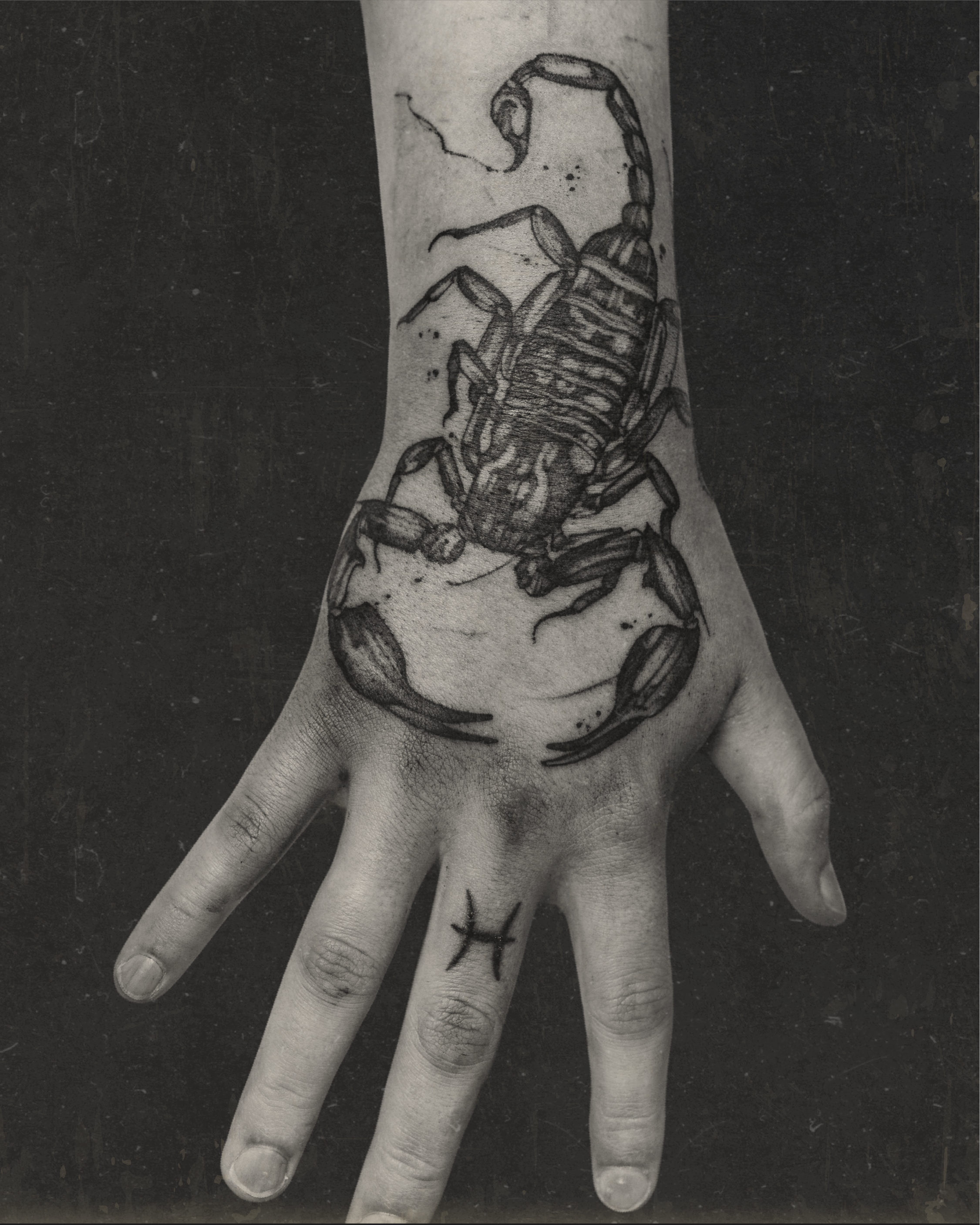 Black ink hand and wrist tattoo of a detailed scorpion with citation mark on finger by Jay C Tattoo, Brighton and Hove tattoo artist, UK