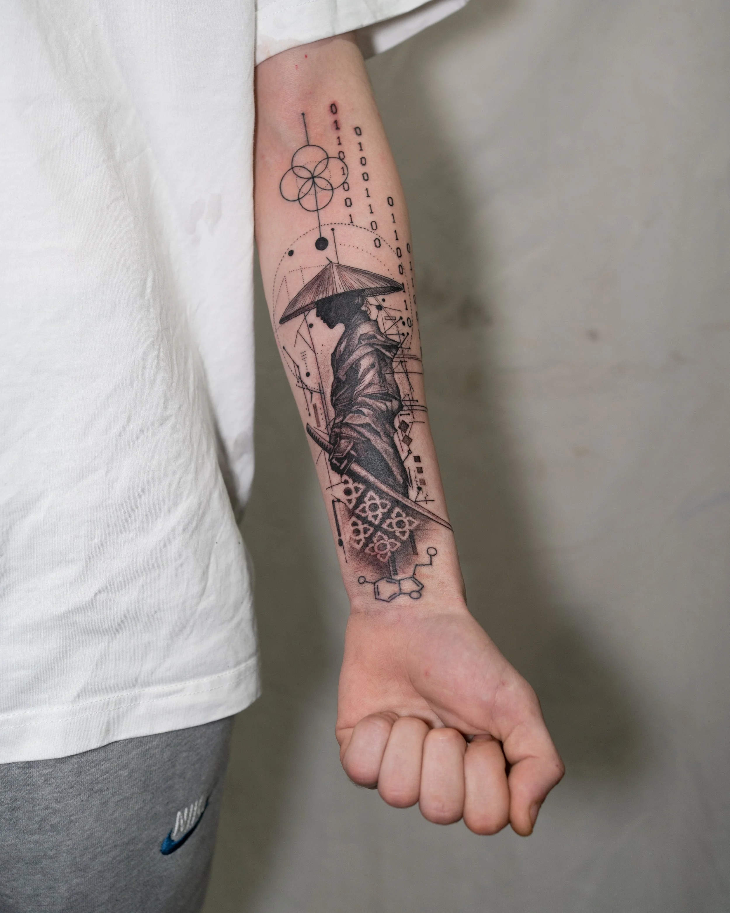 Fine line tattoo of a Samurai holding a sword with geometric elements on forearm by Jay C Tattoo, Brighton tattoo artist, UK
