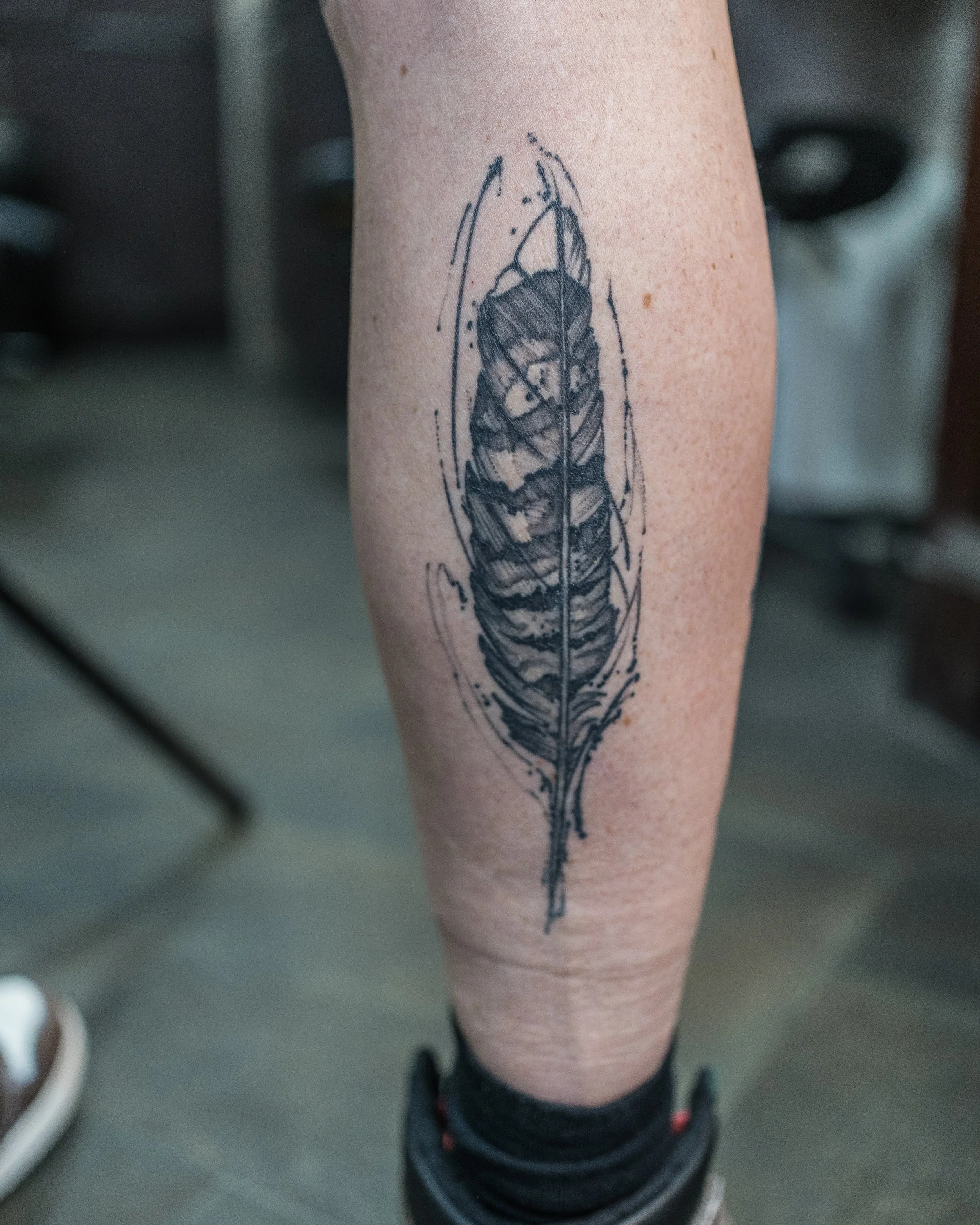 Fine line tattoo of a detailed feather on leg by Jay C Tattoo, Brighton tattoo artist, UK
