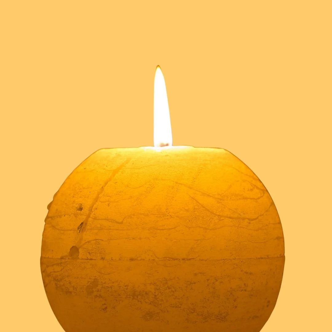 Eine goldene Kerze leuchtet auf warmem Grund – Symbol für das innere Licht, das Orientierung gibt und den eigenen Weg erhellt.