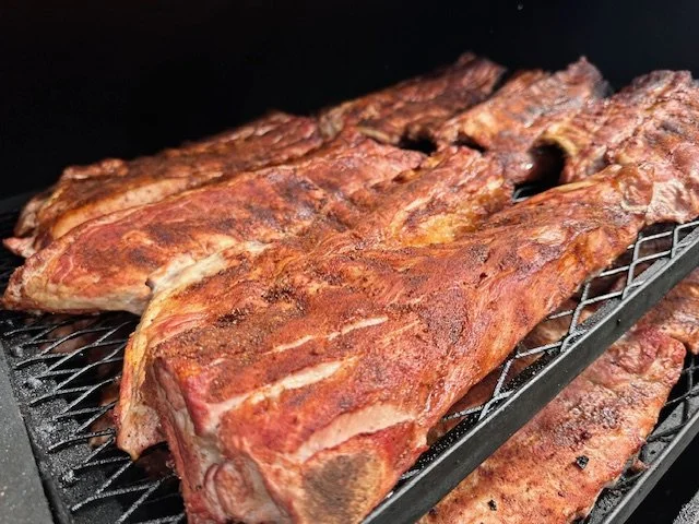 Cooked beef ribs resting on a wire rack