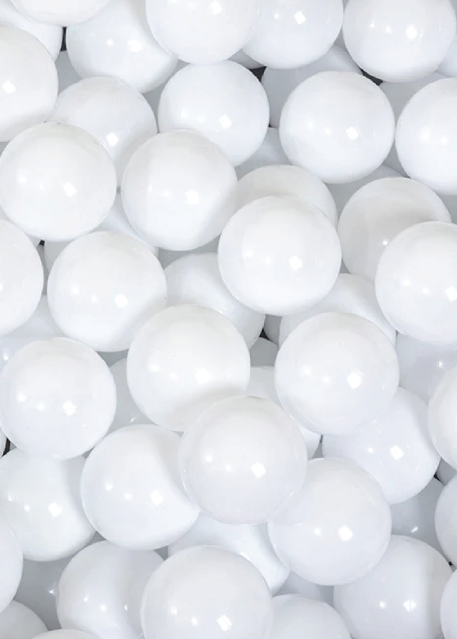Close-up of numerous white ball pit balls stacked together.