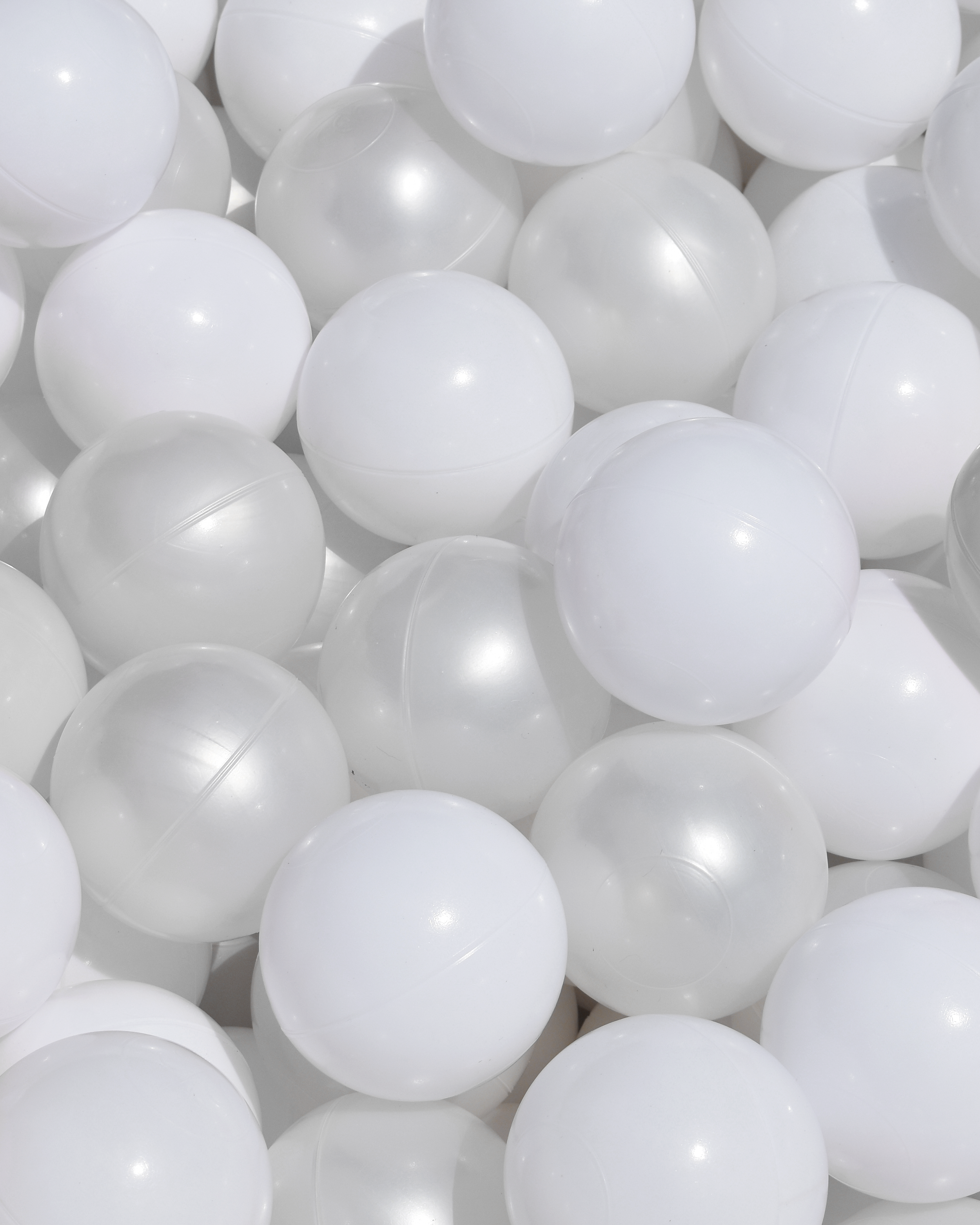 A collection of white and pearl ball pit balls.