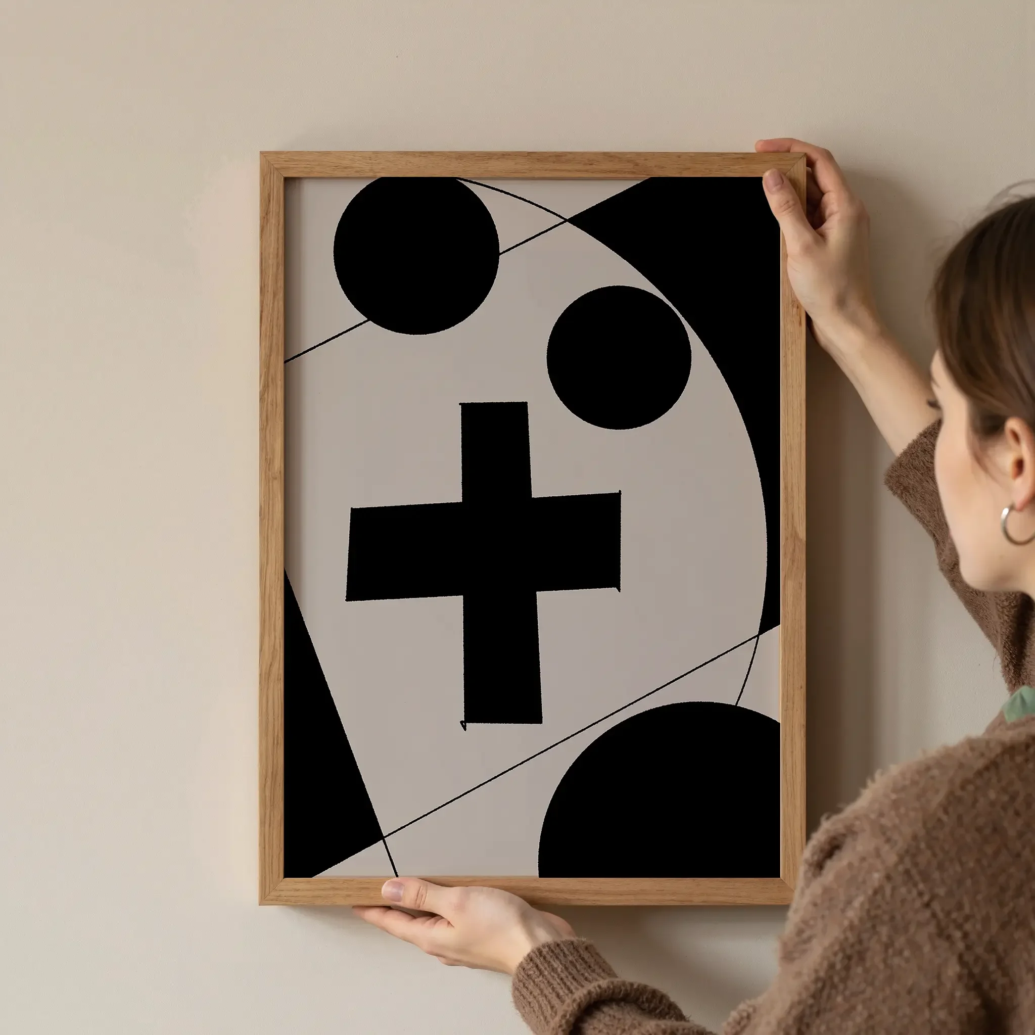 A Christian wall art print featuring cross art poster geometric minimalist design, shown as a framed artwork being hung on the wall.