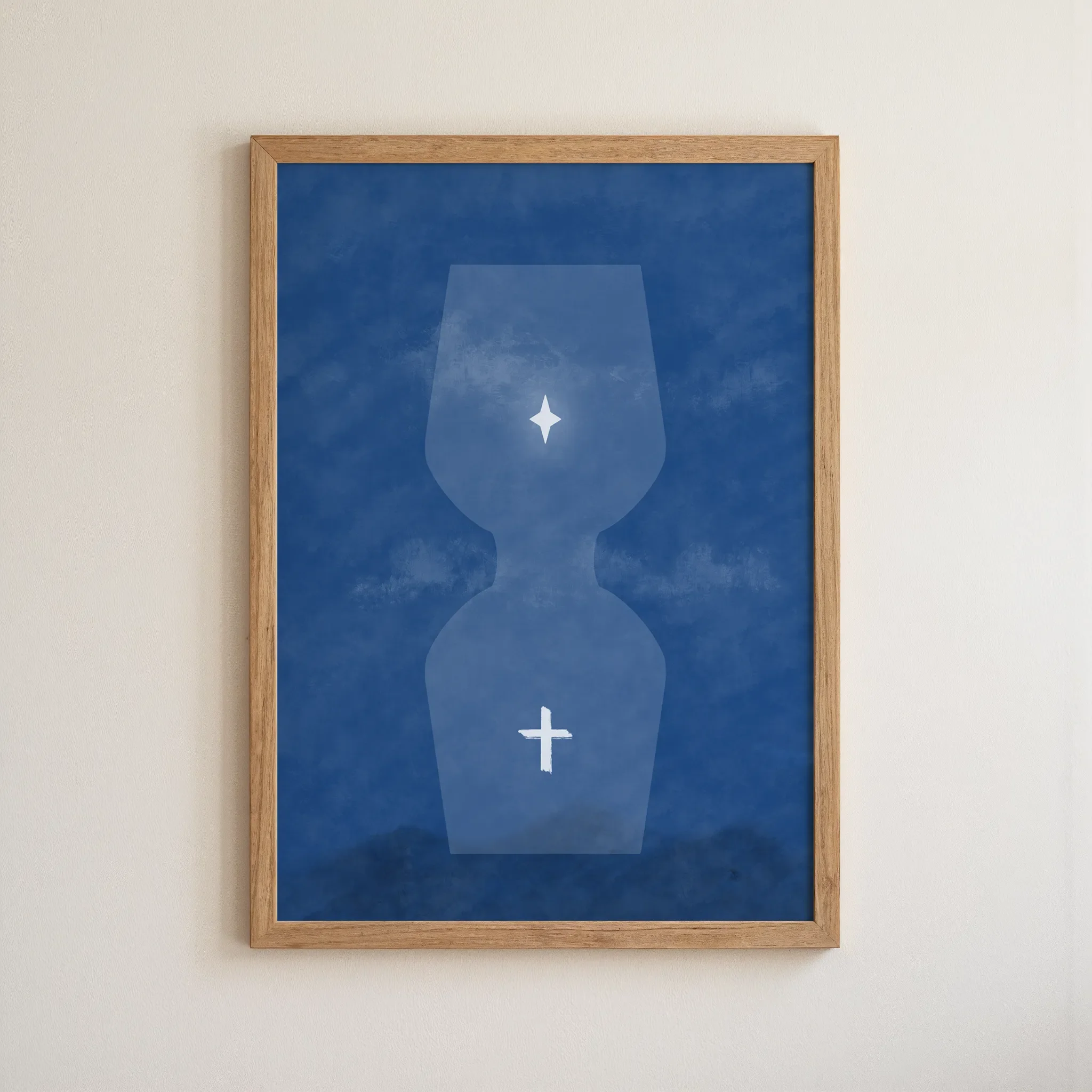 A surreal blue hourglass Christian print with a star above and a glowing cross below, in a simple wooden frame, hangs on a neutral wall.