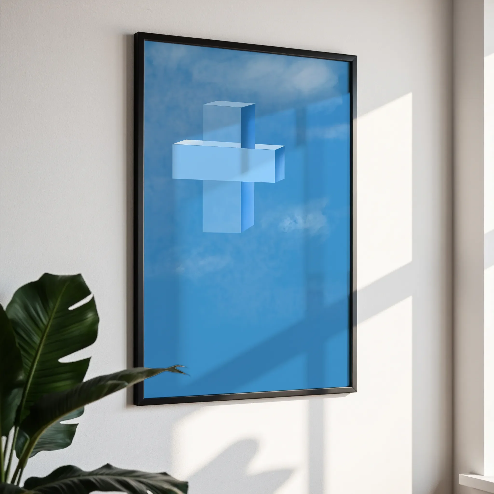 Framed wall art in a simple black frame, photographed from an angled view against a white wall with direct sunlight.