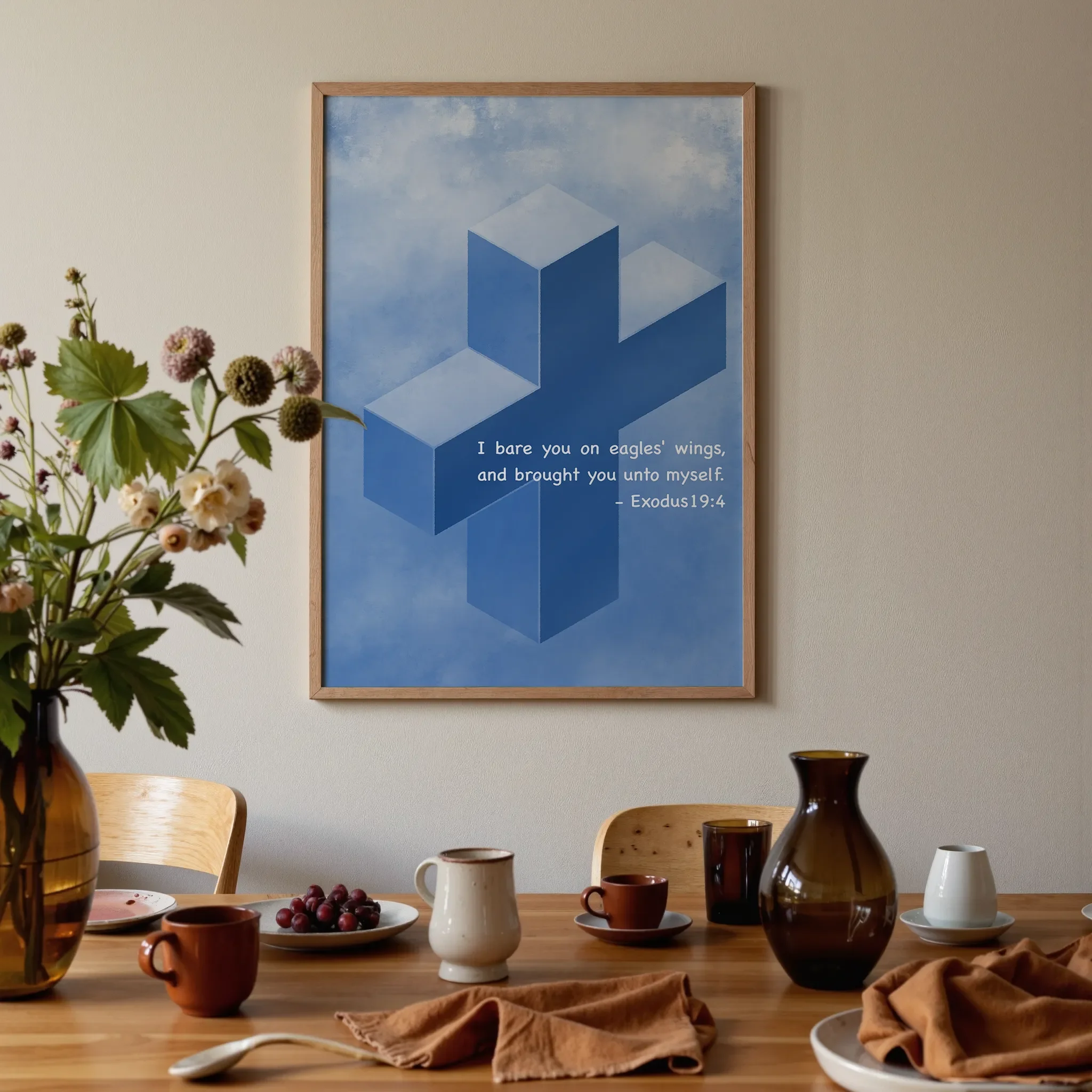 A Scripture wall art featuring a cross hangs above a warm wooden dining table in brown and orange tones. On the table are glass vases, ceramics, flowers, and fruits, softly lit by natural light.