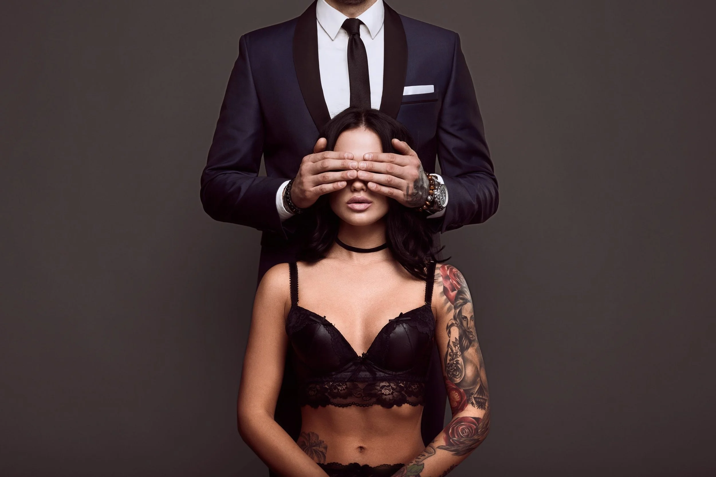 portrait-businessman-elegant-suit-cover-eyes-sexy-woman-with-tattoo-lingerie-scaled.jpg