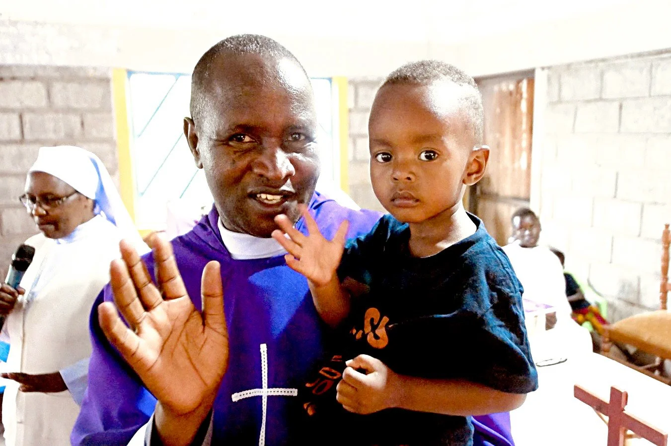 Shalom Home founder Father Francis Gaciata with one of the orphaned children in his care.