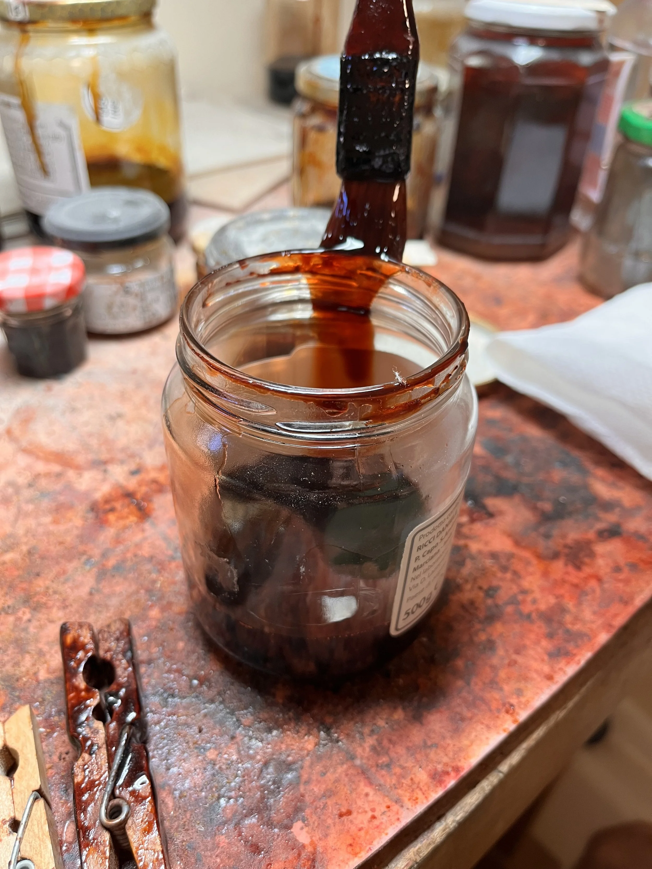 在马可·奥西欧位于克雷莫纳的工作室里，进行小提琴表面处理时，将刷子蘸入彩色酒精清漆中