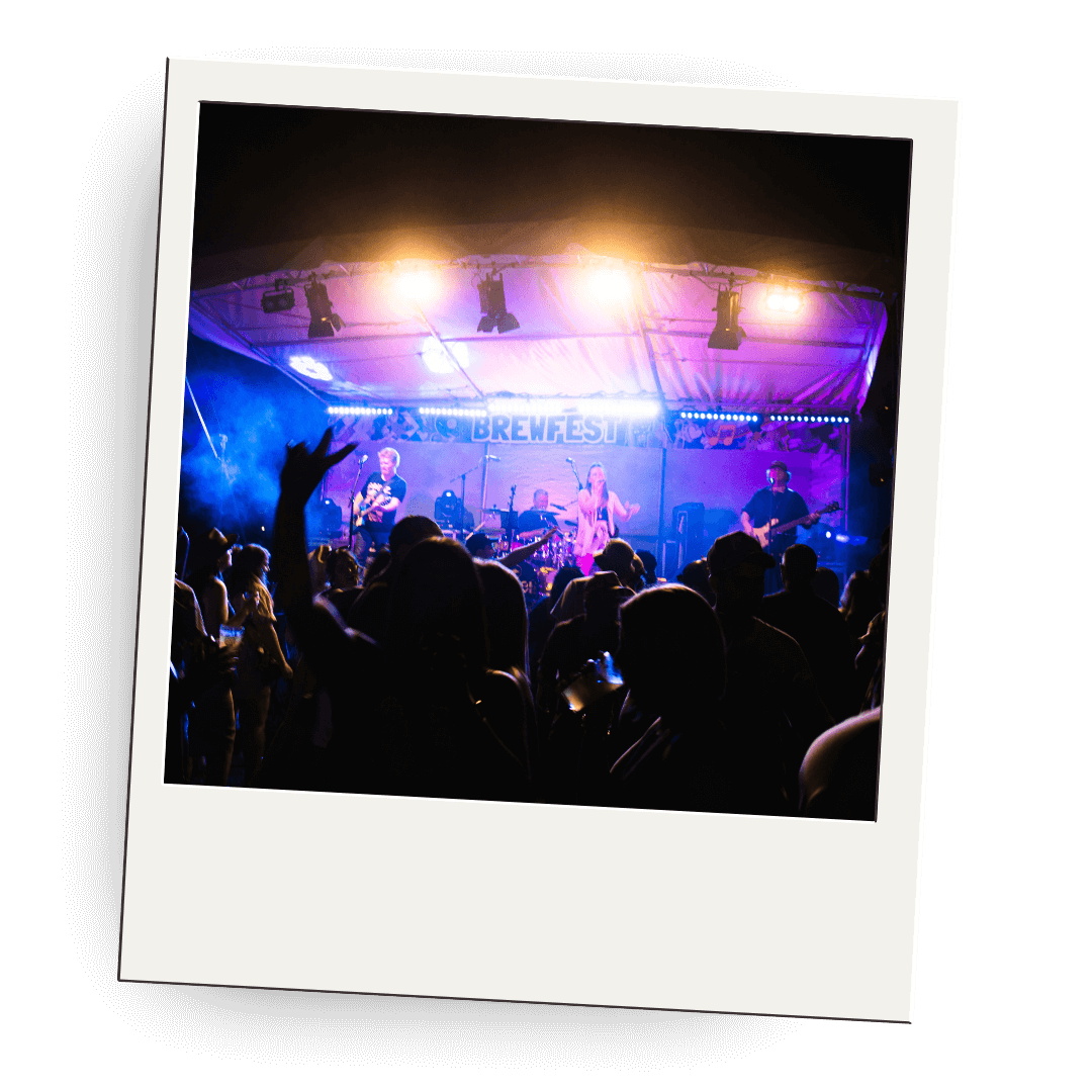 Polaroid picture of a stage with a band performing at a festival called 'Brewfest' with colorful lights and an audience enjoying the concert.