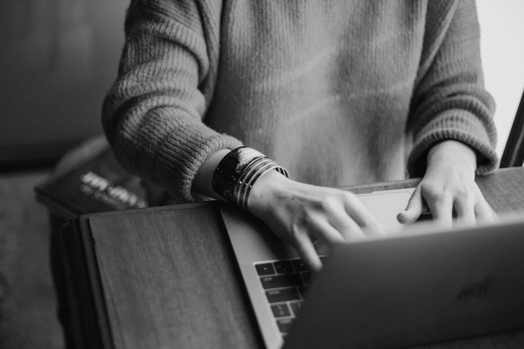 man typing on his mac laptop