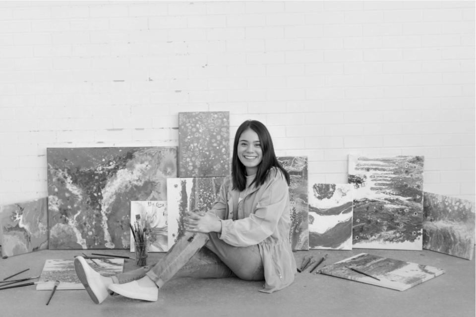 Artist with her paintings