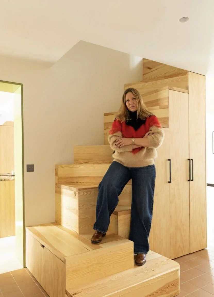 Femme debout sur un escalier en bois dans une maison moderne