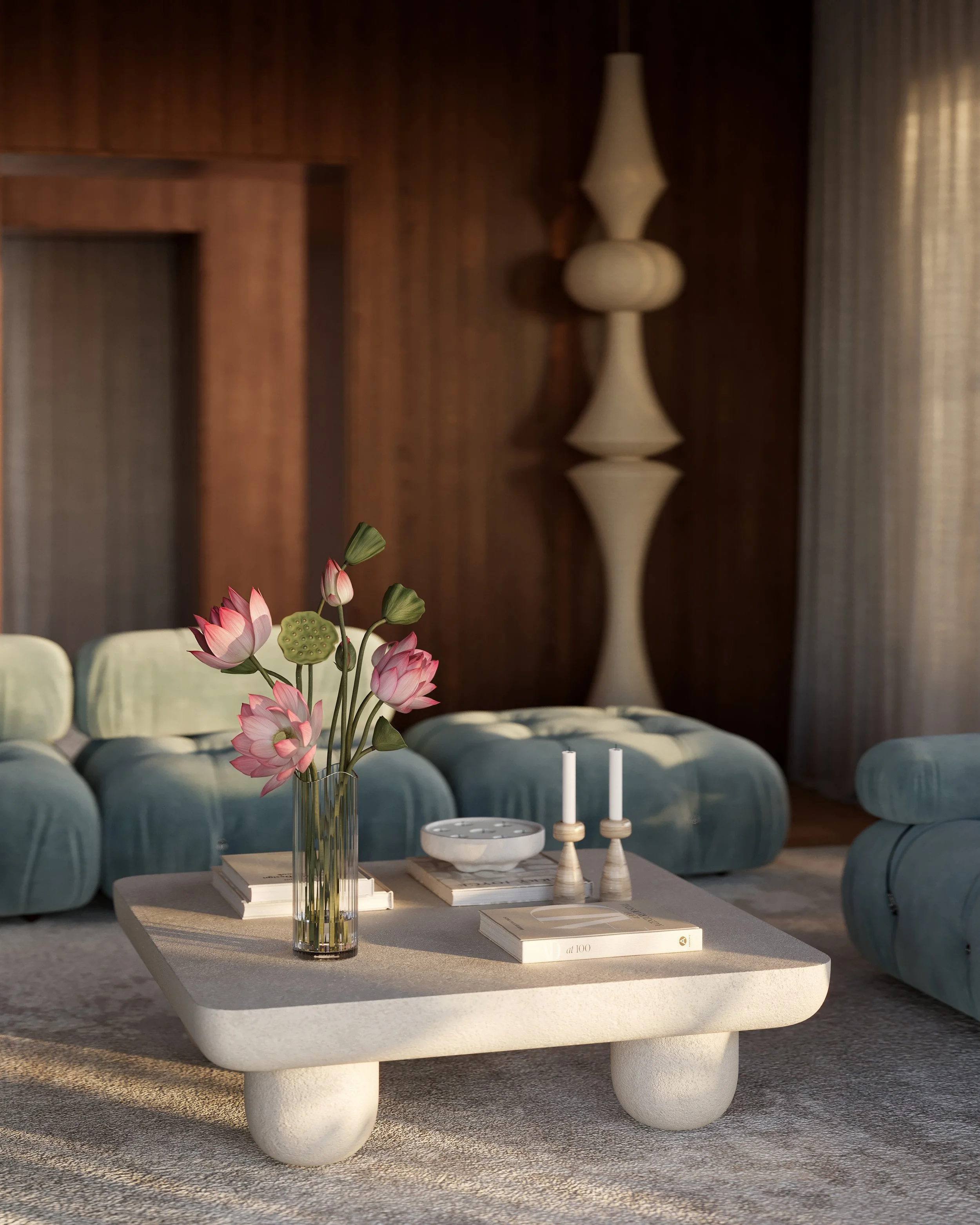 Living room with a beige coffee table, pink lotus flower bouquet in a glass vase, candles, books, and a velvet sofa in a modern interior with wood-paneled walls and a tall decorative lamp.