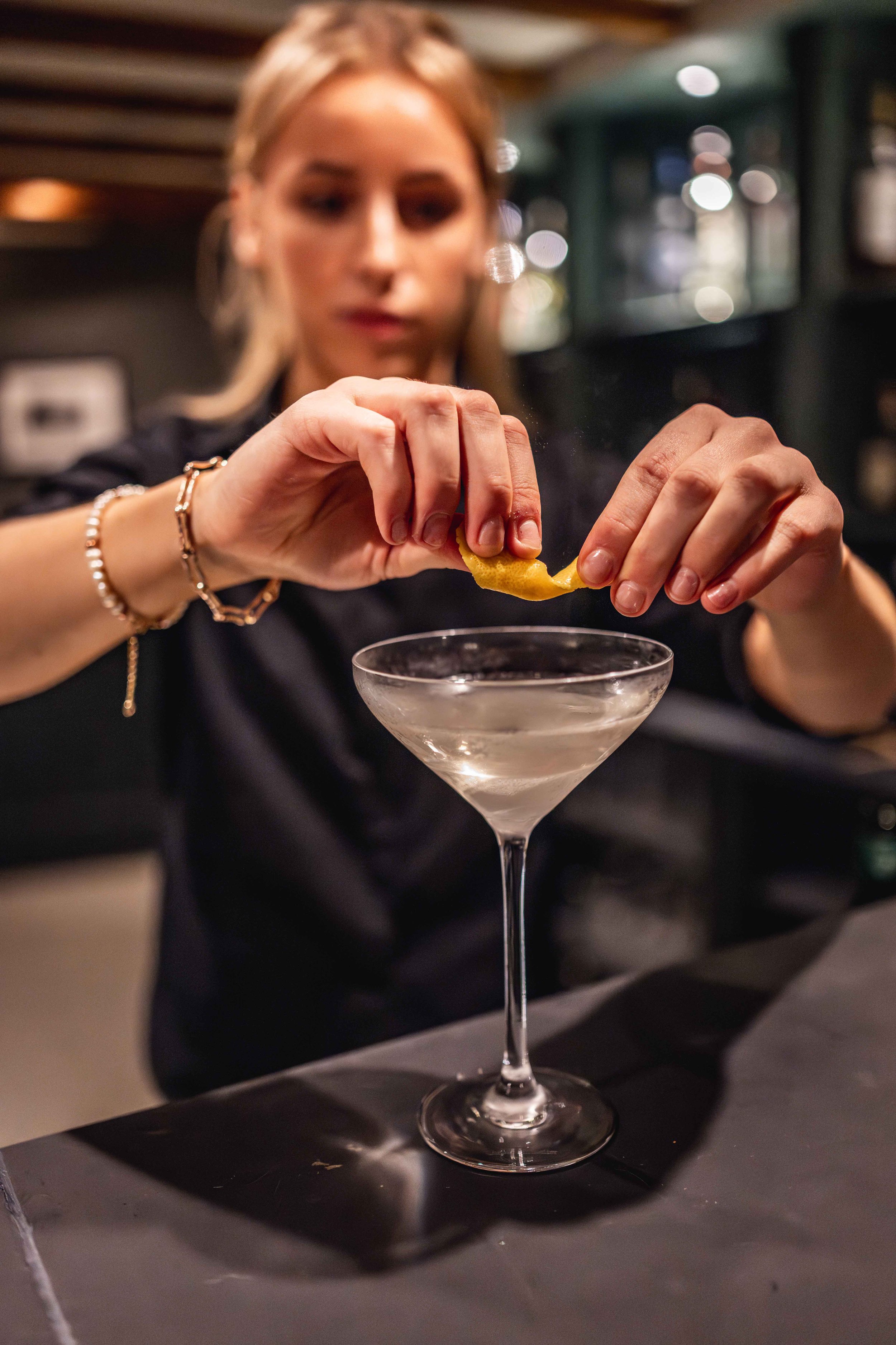 Hospitality staff member at Loyton Lodge mixing a cocktail for guests.