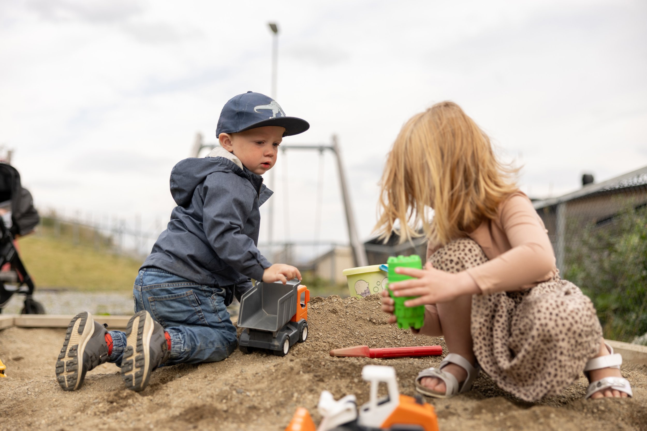 Bilde av barn som leker i sanskasse.
