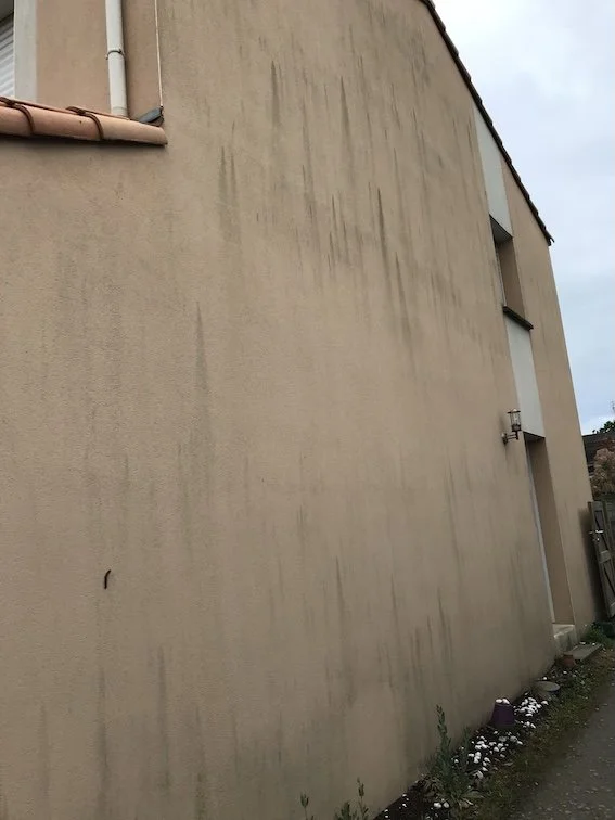 Façade et pignon à Bouguenais fortement marqués par des traces noires de pollution et dépôts tenaces, nécessitant un nettoyage spécialisé.
