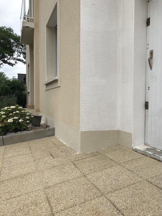 Maison contemporaine située à Nantes, où les enduits décollés en bas de murs ont été piqués puis remplacés par un nouvel enduit formant barrière contre les remontées d’humidité.